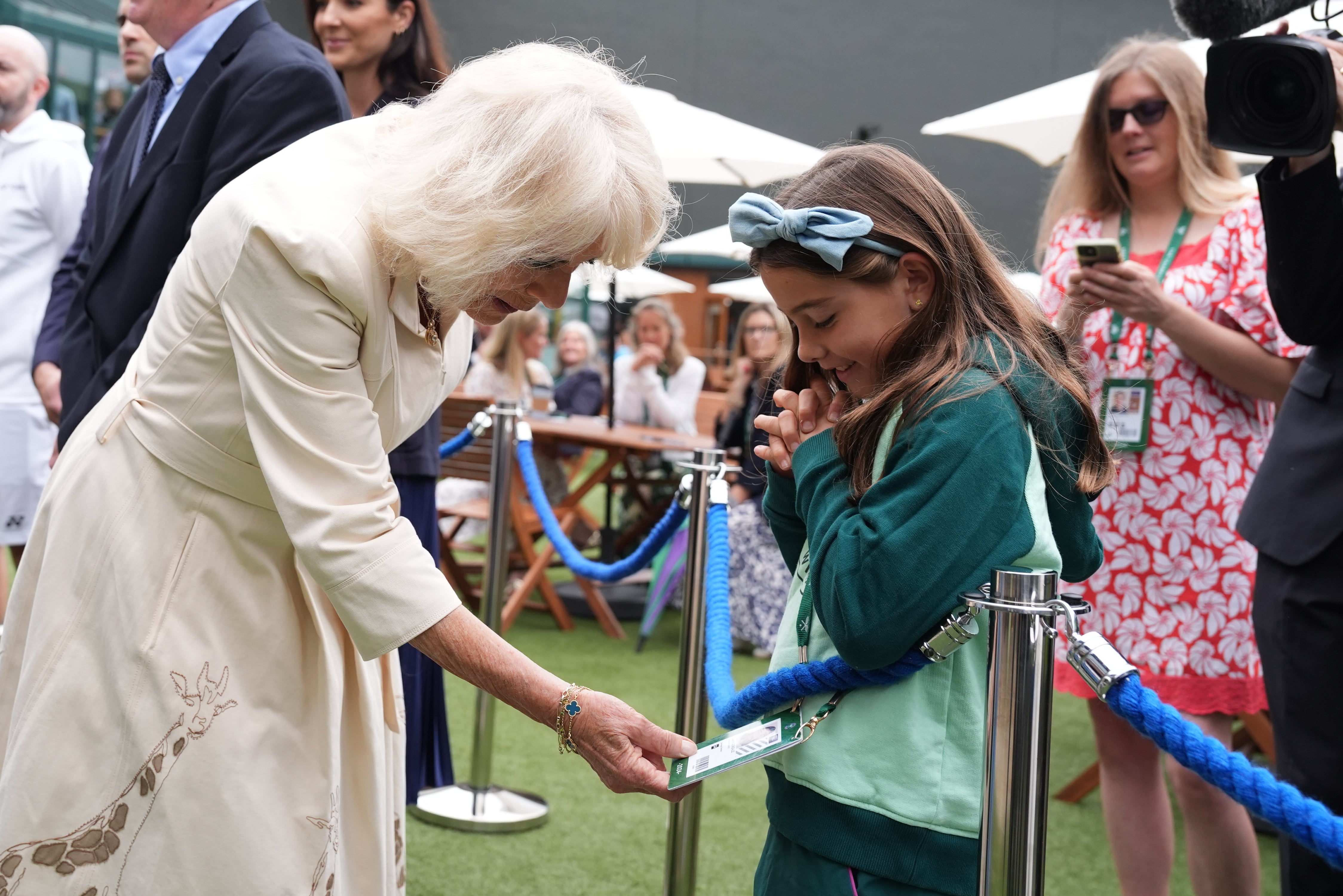 Camila inspects the Wimbledon pass belonging to Camila, daughter of Mexican tennis player Santiago Gonzalez (Jordan Pettitt/PA)