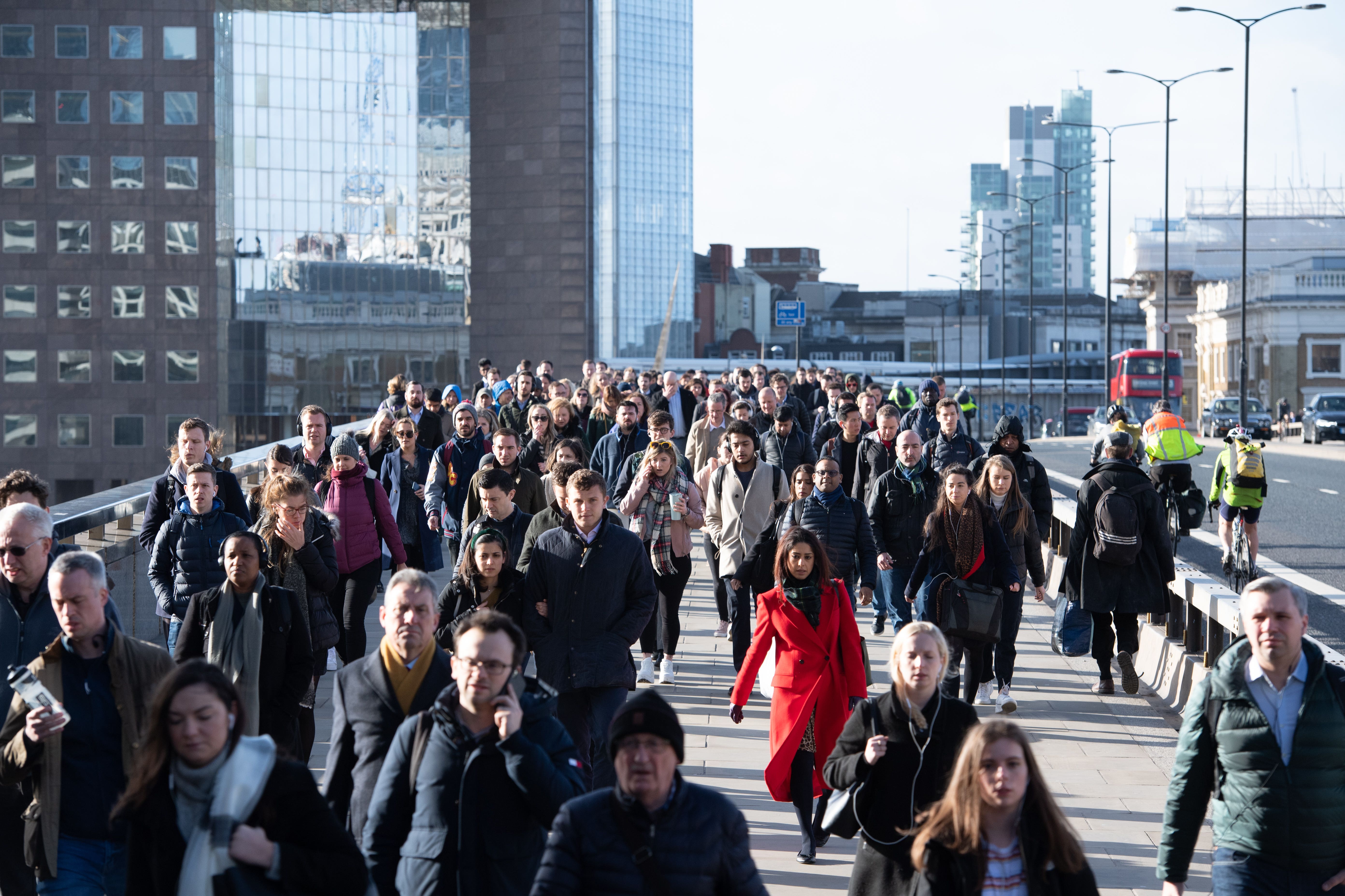 Commuters crossing London Bridge, in central London, during the morning rush hour