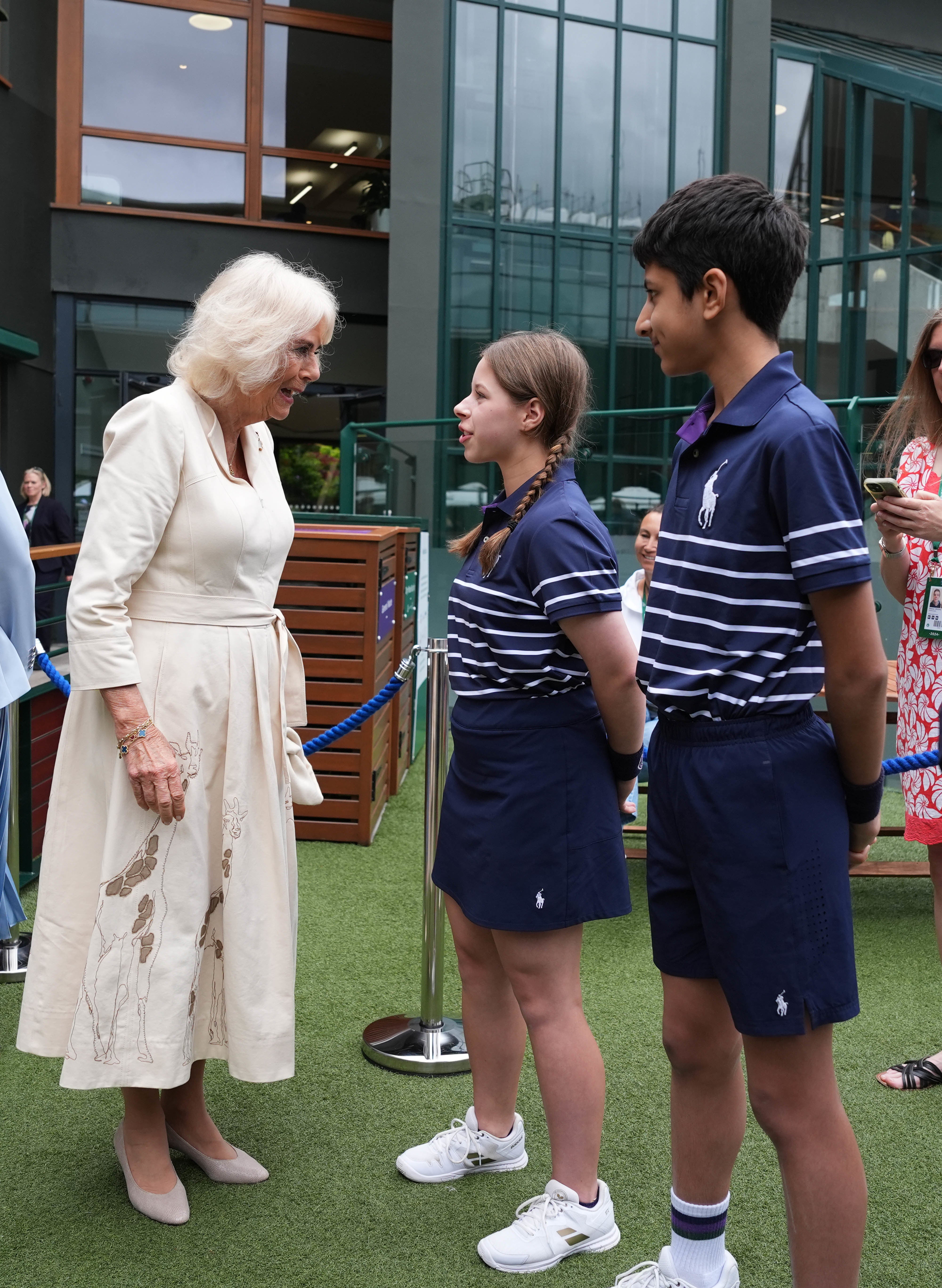 Camilla in her giraffe dress meeting ball kids Natalia and Yug (Jordan Pettitt/PA)