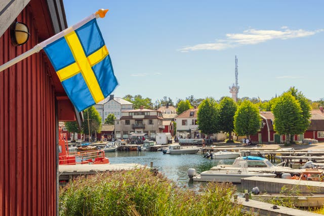 <p>A swedish flag by the harbor in the village of Sandhamn on SandÃ¶n (island) in Stockholm archipelago</p>