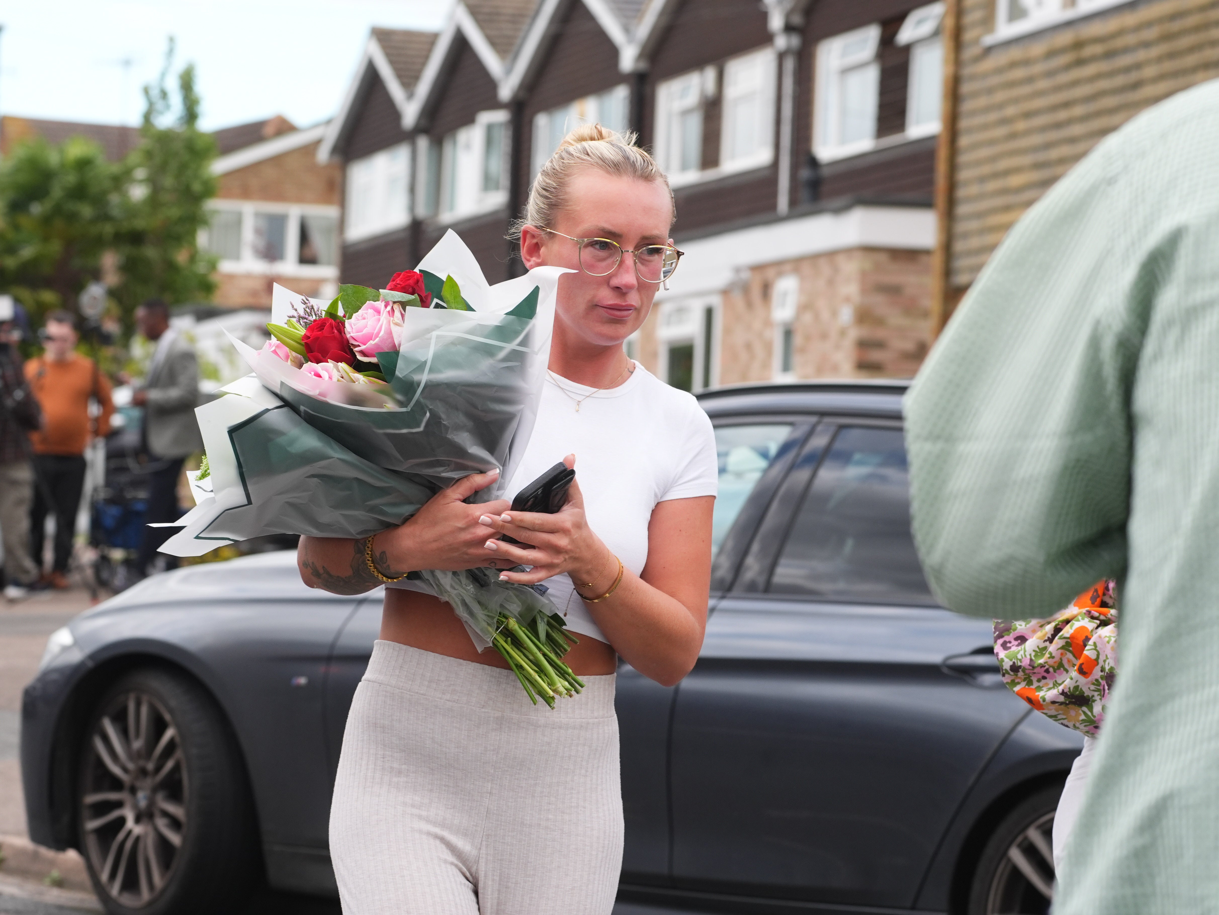 A woman leaves floral tributes at the scene