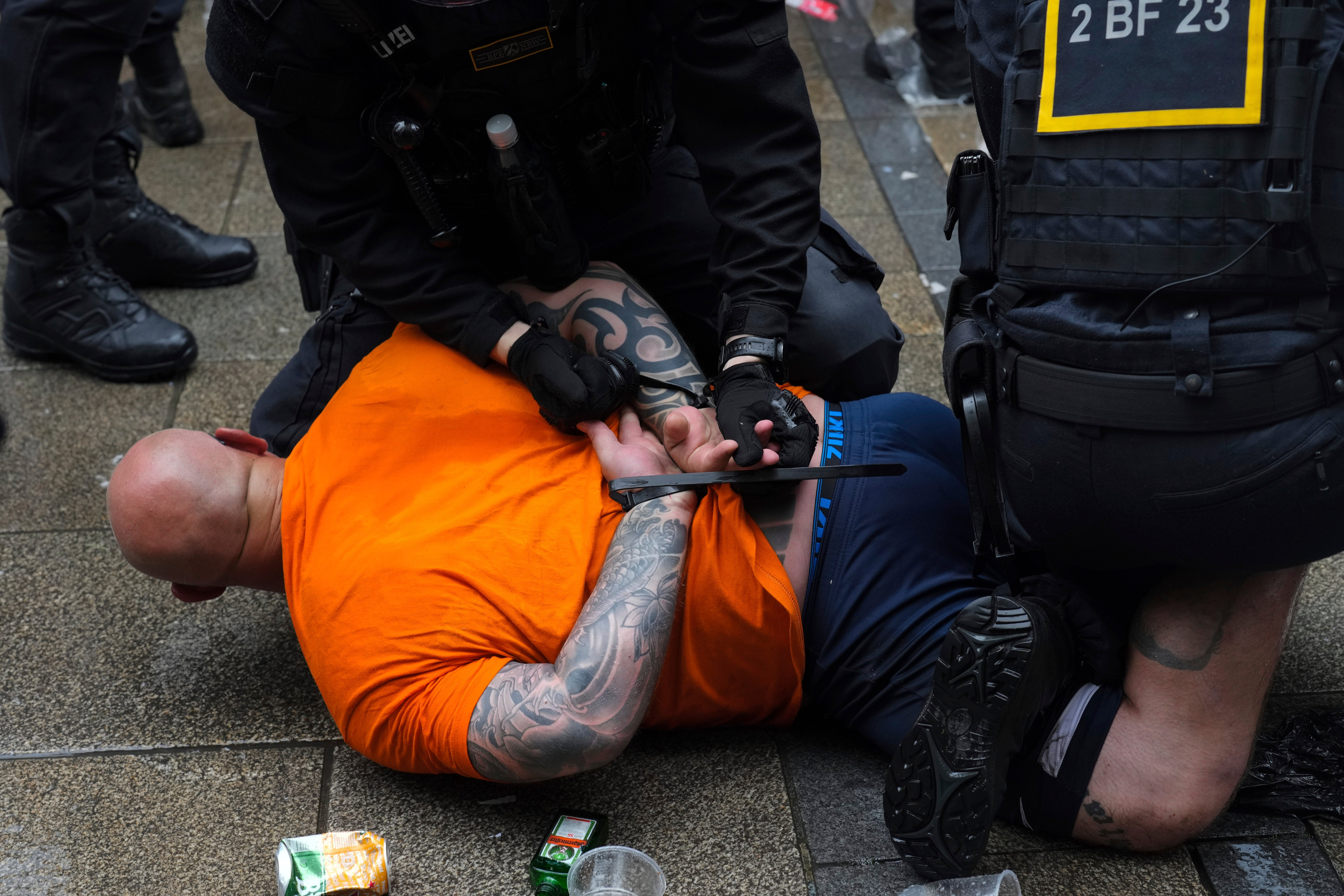 Police officers detain a fan ahead of a semi final match between Netherlands and England