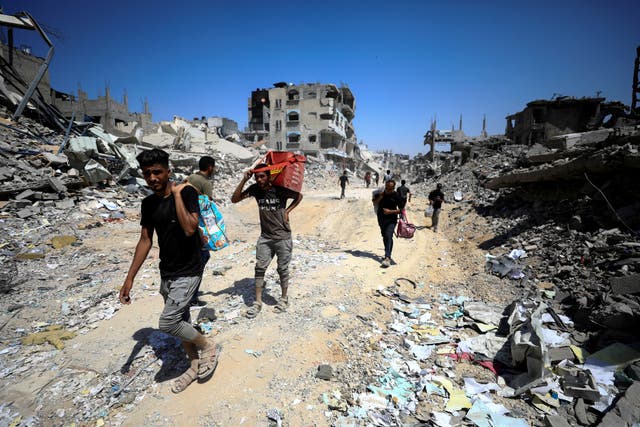 <p>Palestinians inspect damage, after Israeli forces withdrew from Shejaiya neighborhood, in eastern part of Gaza city</p>