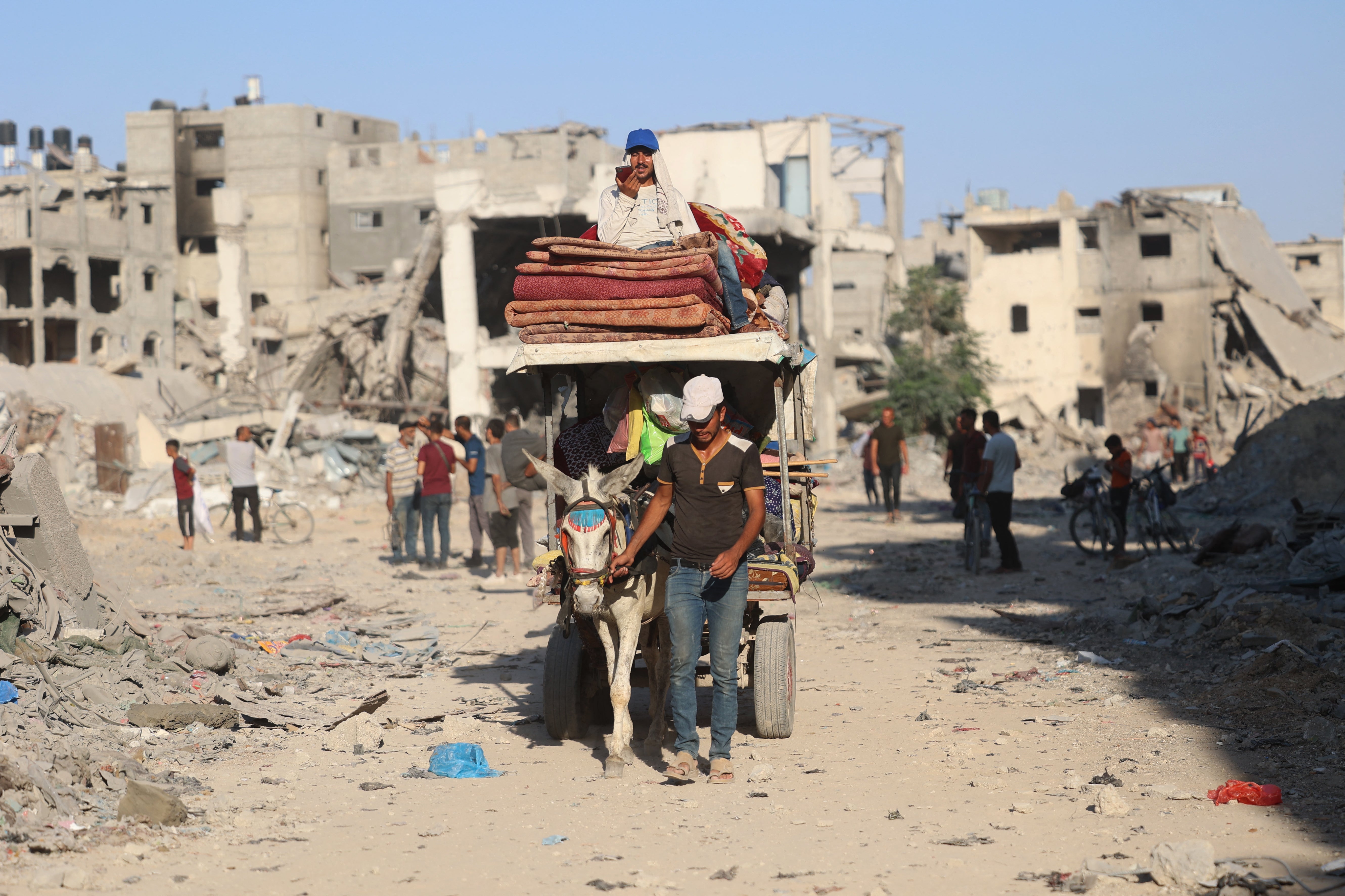 A Palestinian man leads a donkey cart past the destroyed buildings and rubble after the Israeli military withdrew from the Shujaiya neighbourhood, east of Gaza City
