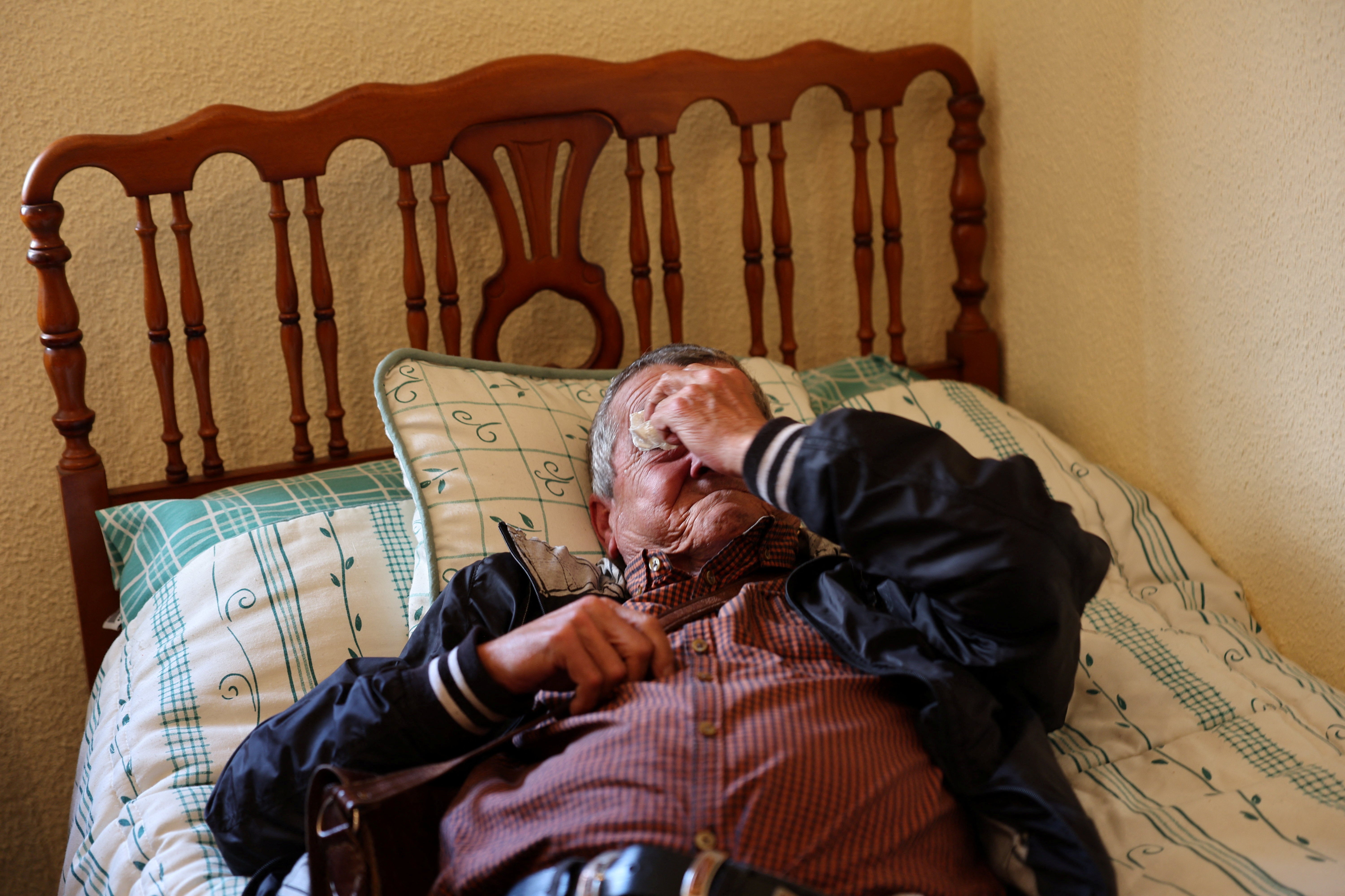 Francisco Carrillo reacts as he lies in the bed of his new apartment