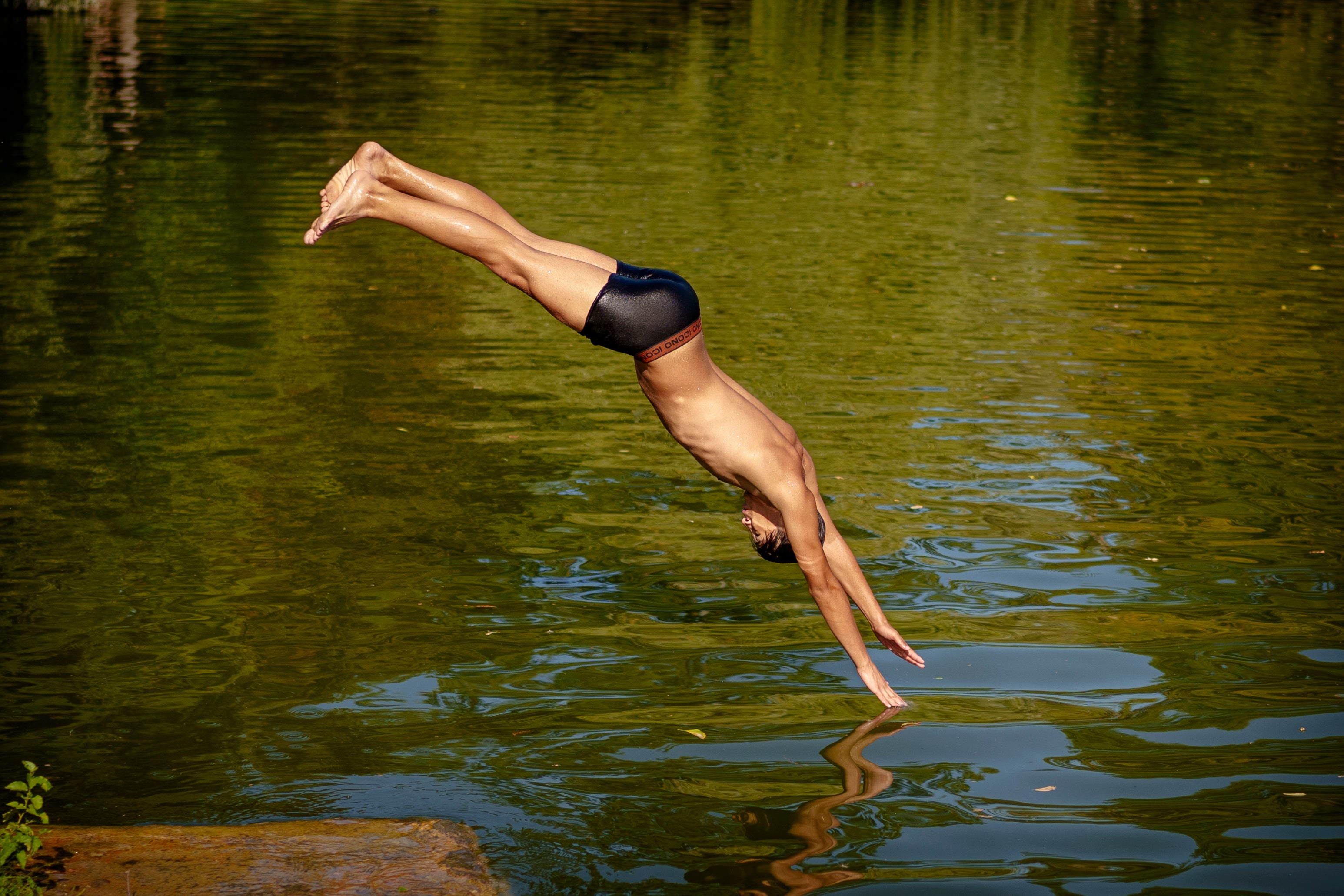 A boy jumps in a lake in Bucharest, Romania, Tuesday, July 9, 2024, as temperatures exceeded 39 degrees Celsius