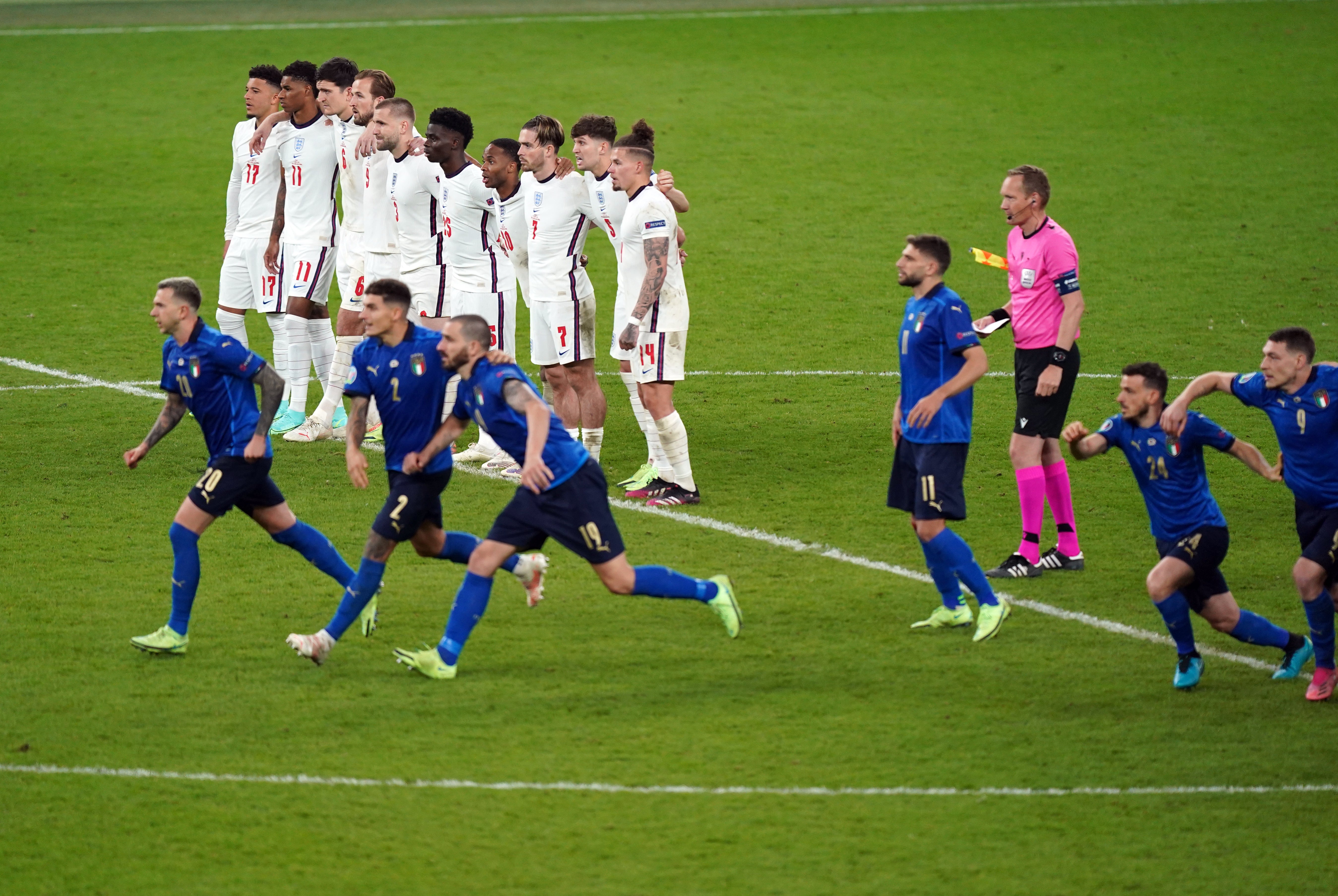 England players look on as Italy celebrate winning the Euro 2020 final on penalties (Mike Egerton/PA)