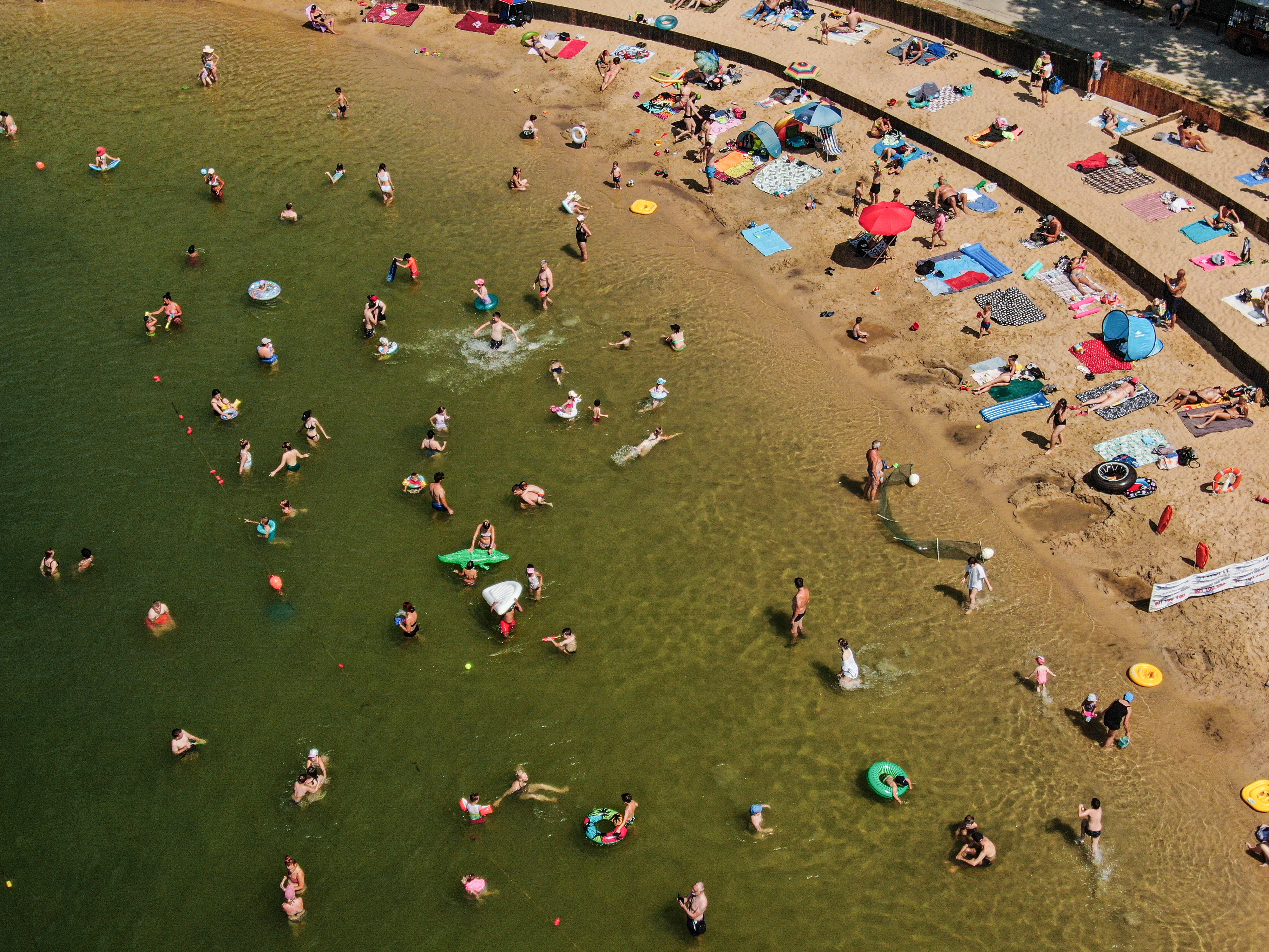 An aerial view of people refreshing and sunbathing on a lake due to high temperatures in Krakow, Poland on July 10, 2024