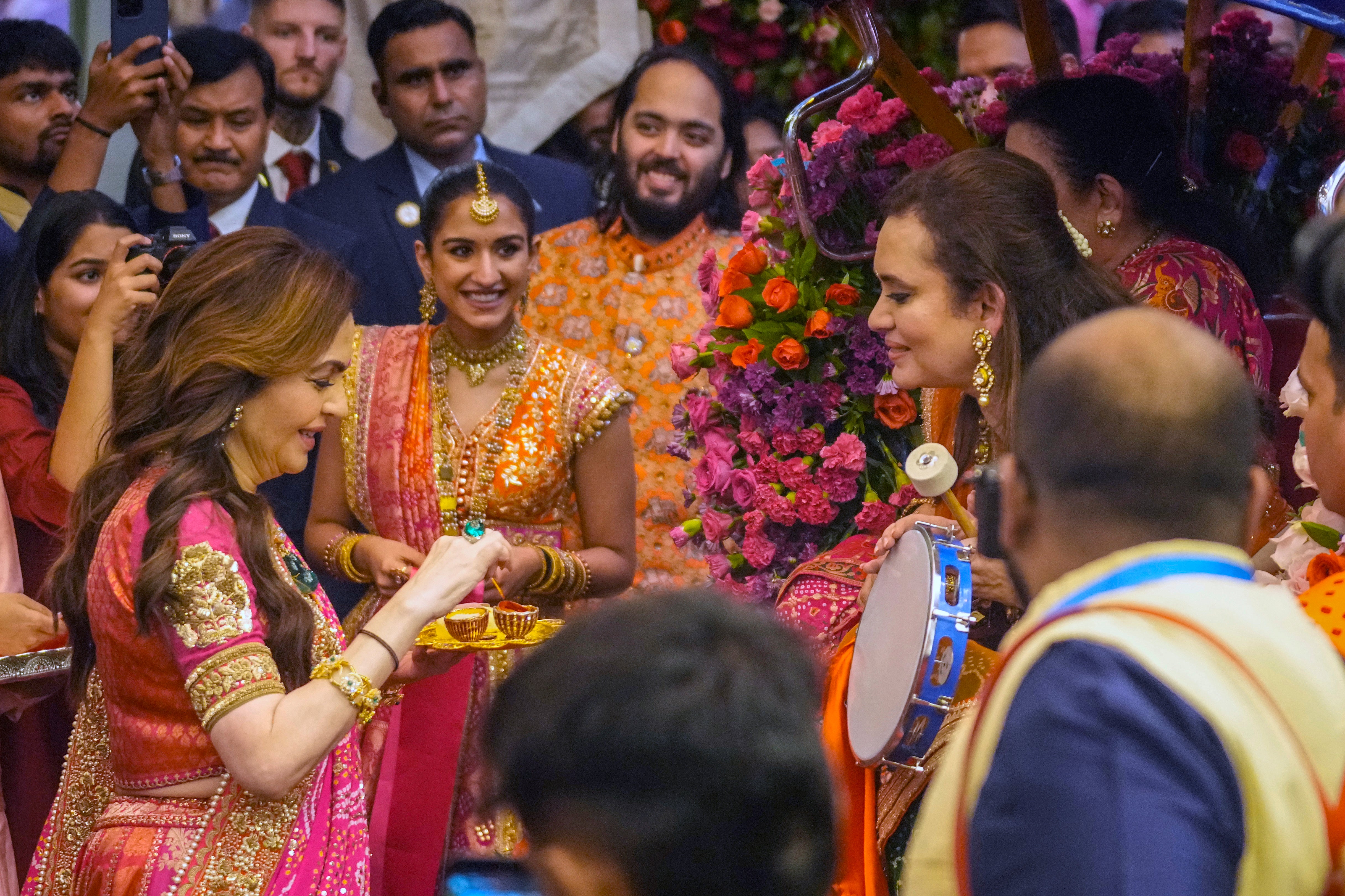 Nita Ambani, left, wife of Mukesh, along with son Anant, right, and Anant’s fiancee, greets guests during a pre-wedding ceremony at their residence Antilia in Mumbai, India on Wednesday