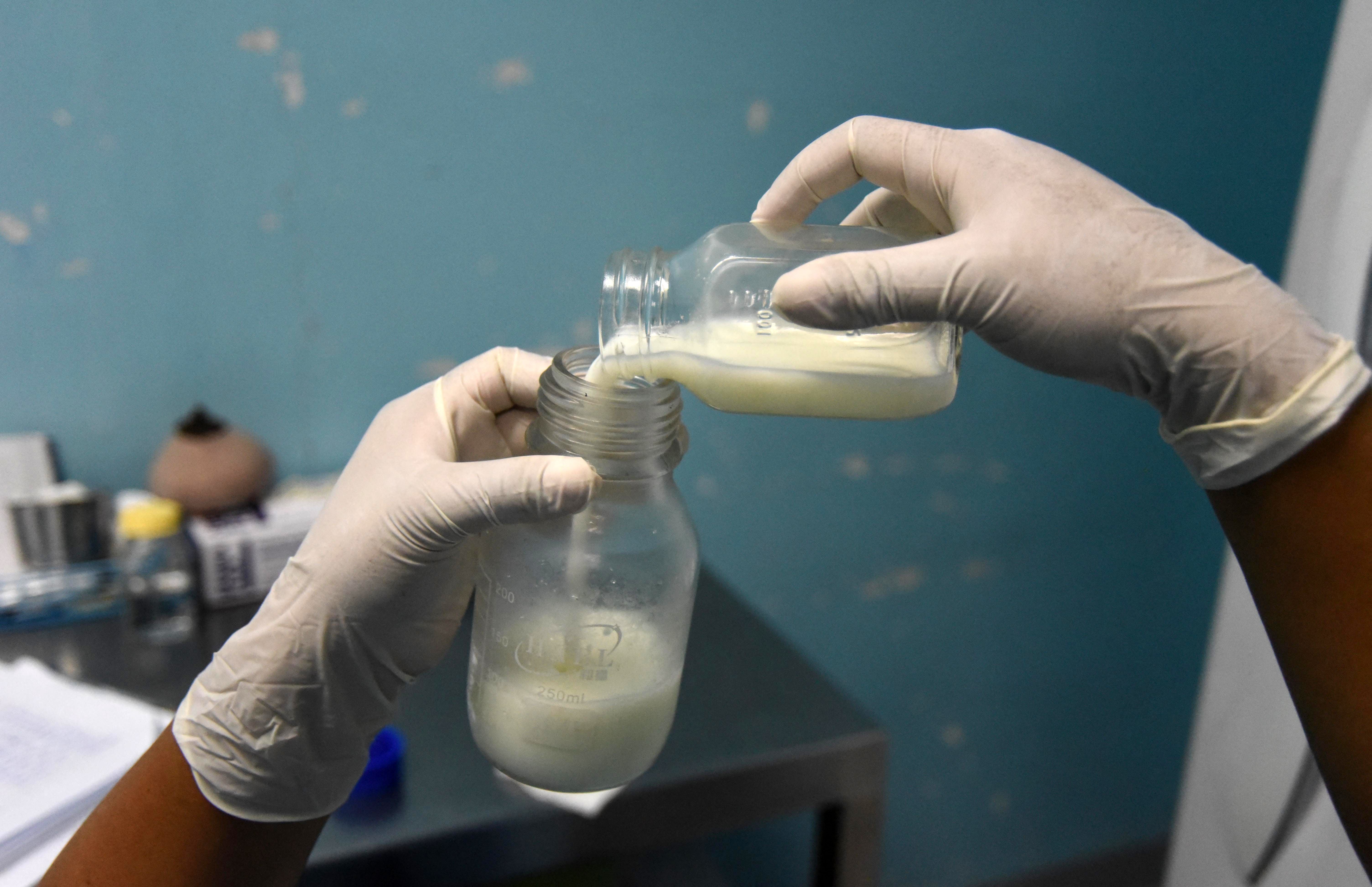 <p>A doctor pours donated breast milk at a milk bank in Guatemala City</p>