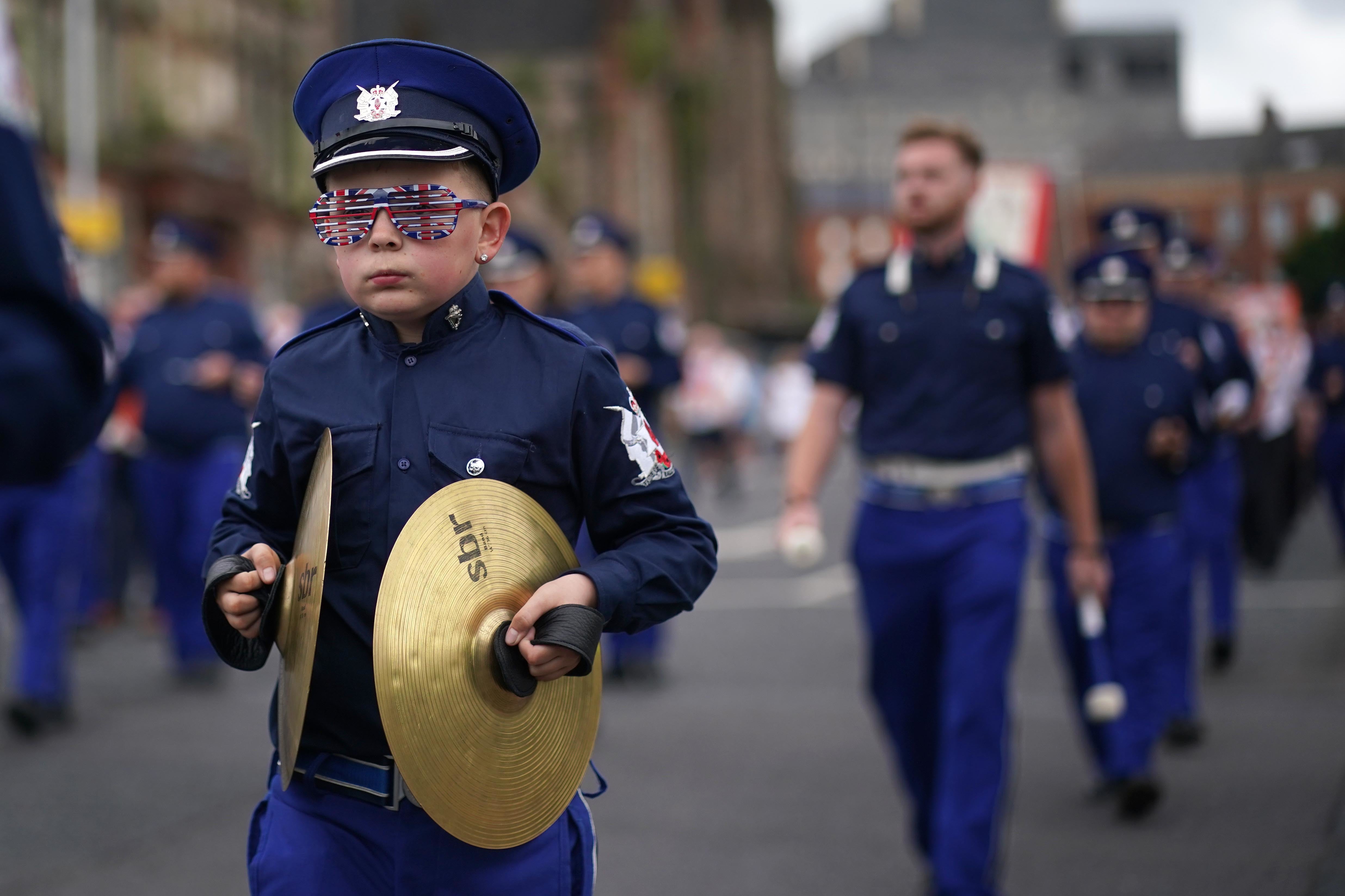 A boy marches with cymbals through Belfast in uniform (Brian Lawless/PA)
