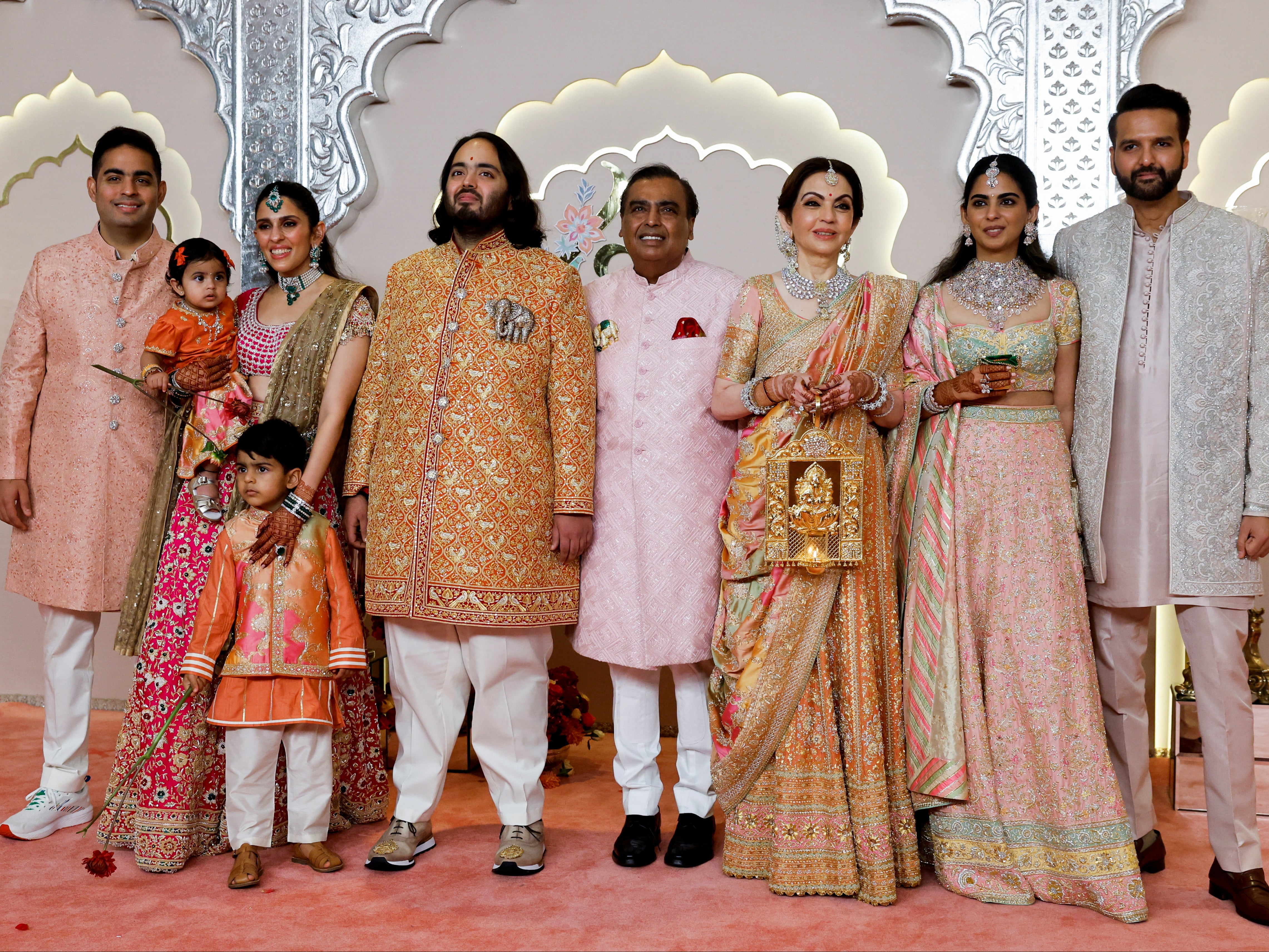 Groom Anant Ambani (wearing an elephant motif) with his brother Akash Ambani (L), sister-in-law Shloka Mehta, father Mukesh Ambani (centre), sister Isha Ambani, and brother-in-law Anand Piramal on the red carpet on Friday