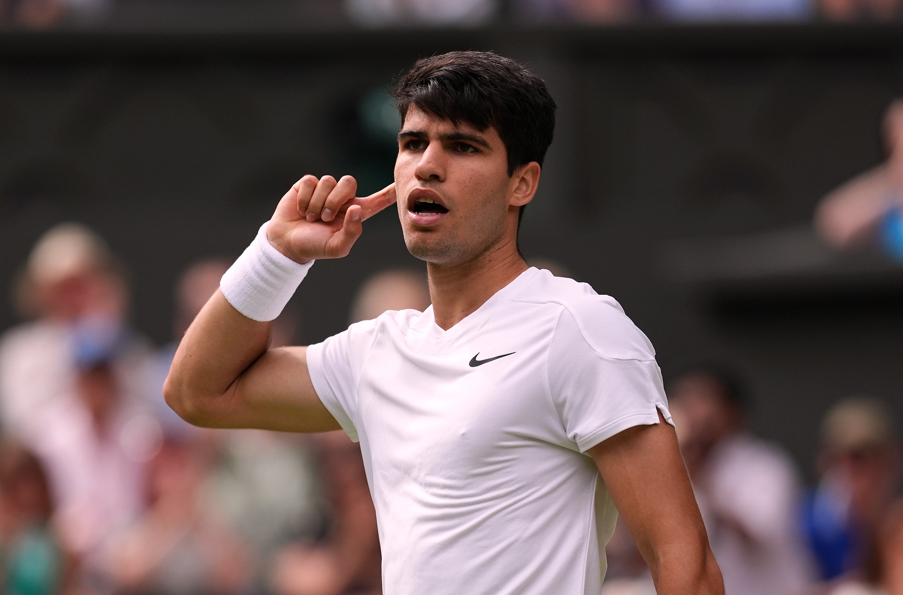 Carlos Alcaraz puts his finger to his ear during his semi-final win (Jordan Pettitt/PA)