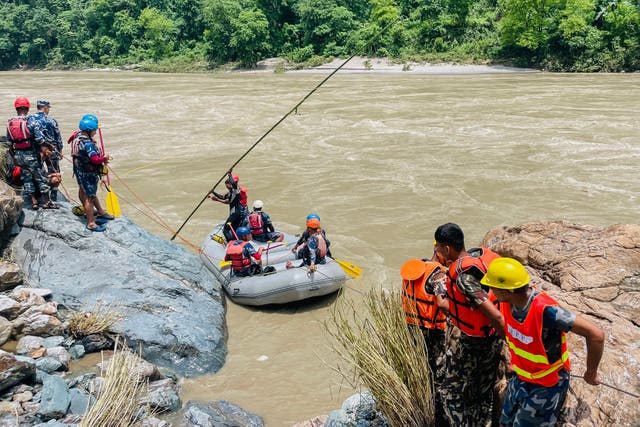 <p>Members of Nepal’s Armed Police Force (APF) search for survivors in the Trishuli River at the site of a landslide following heavy rainfall in Simaltar on 13 July, 2024</p>