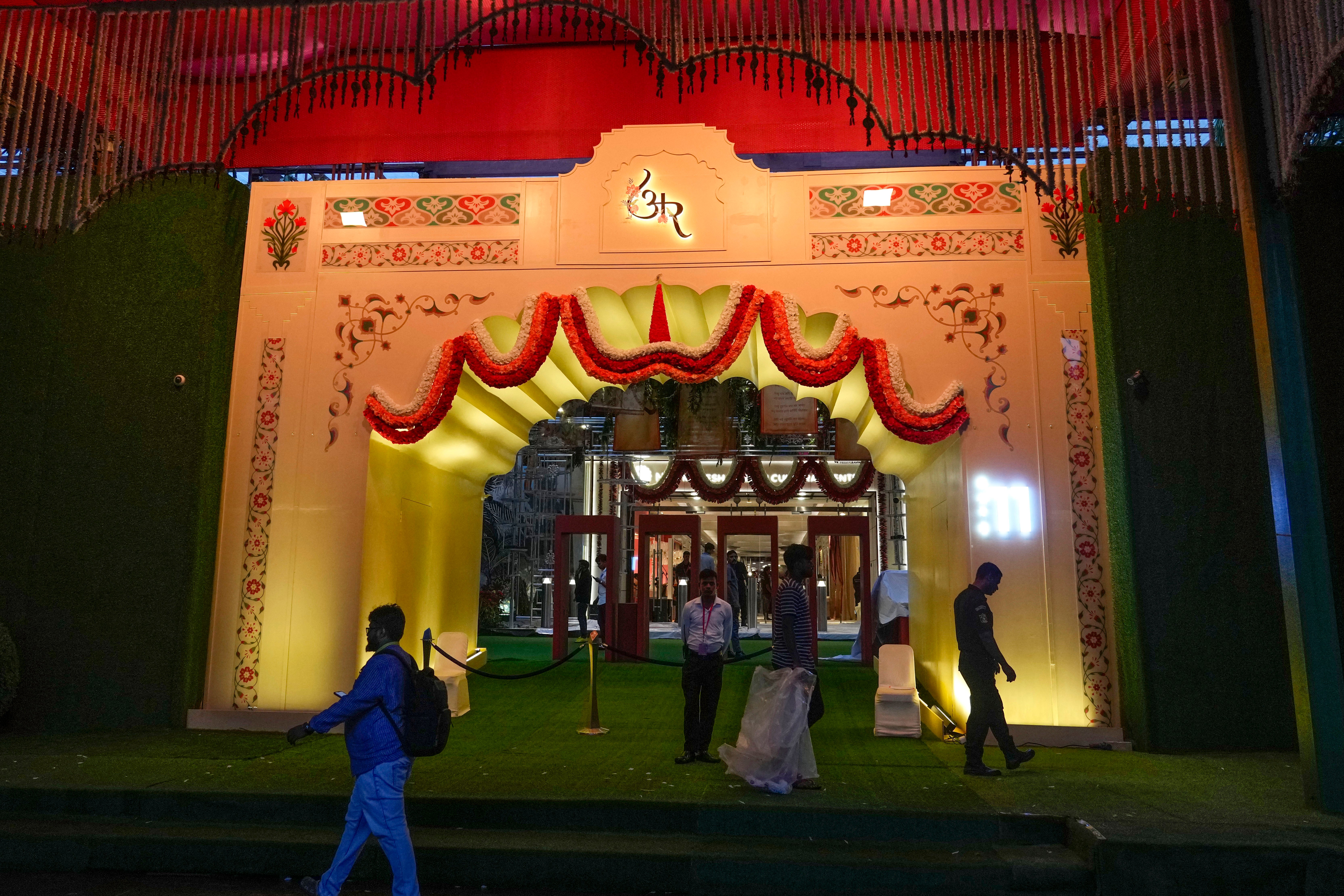 People walk past the venue decorated with lights ahead