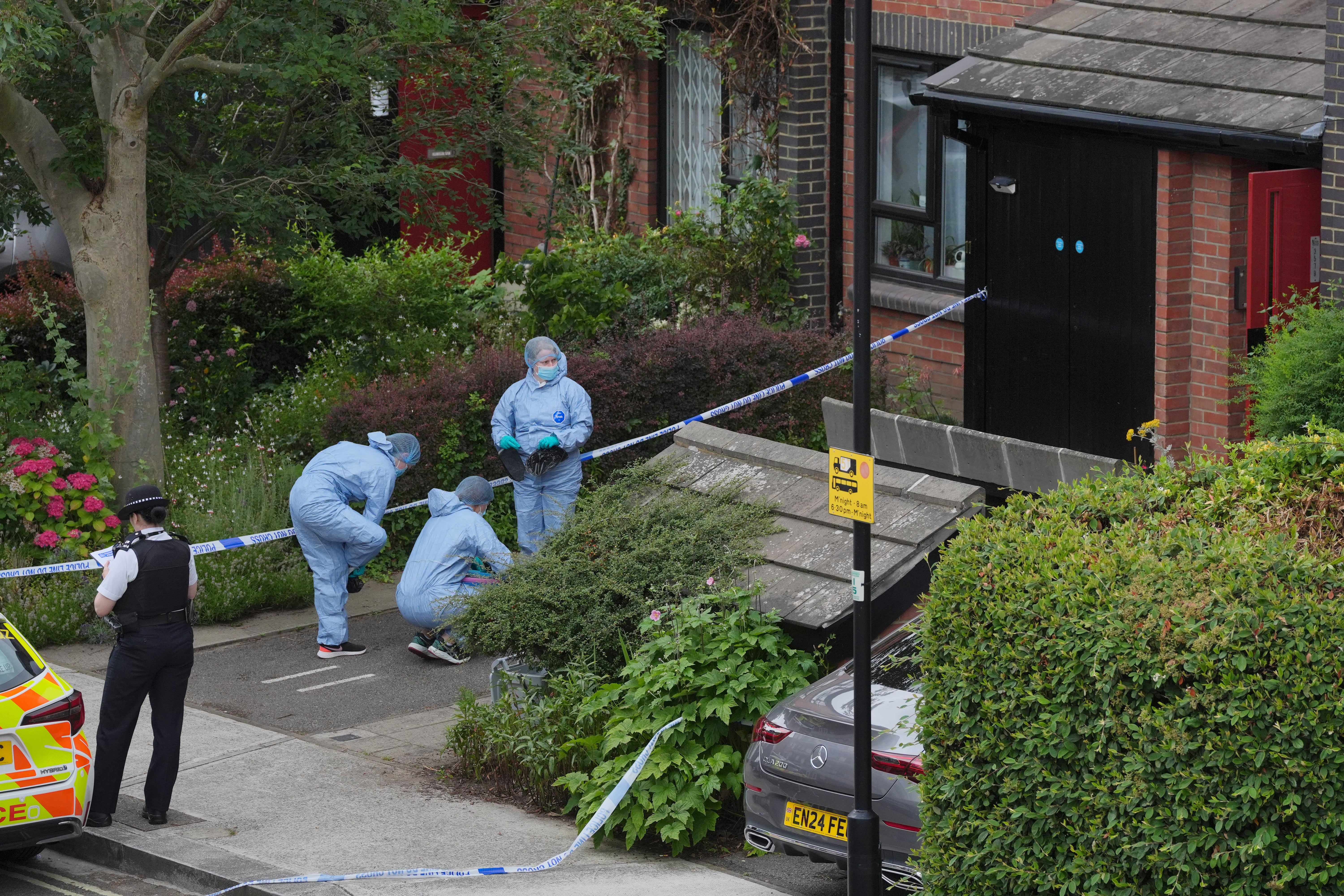 Police officers working in a crime scene at a property in Shepherd’s Bush, west London