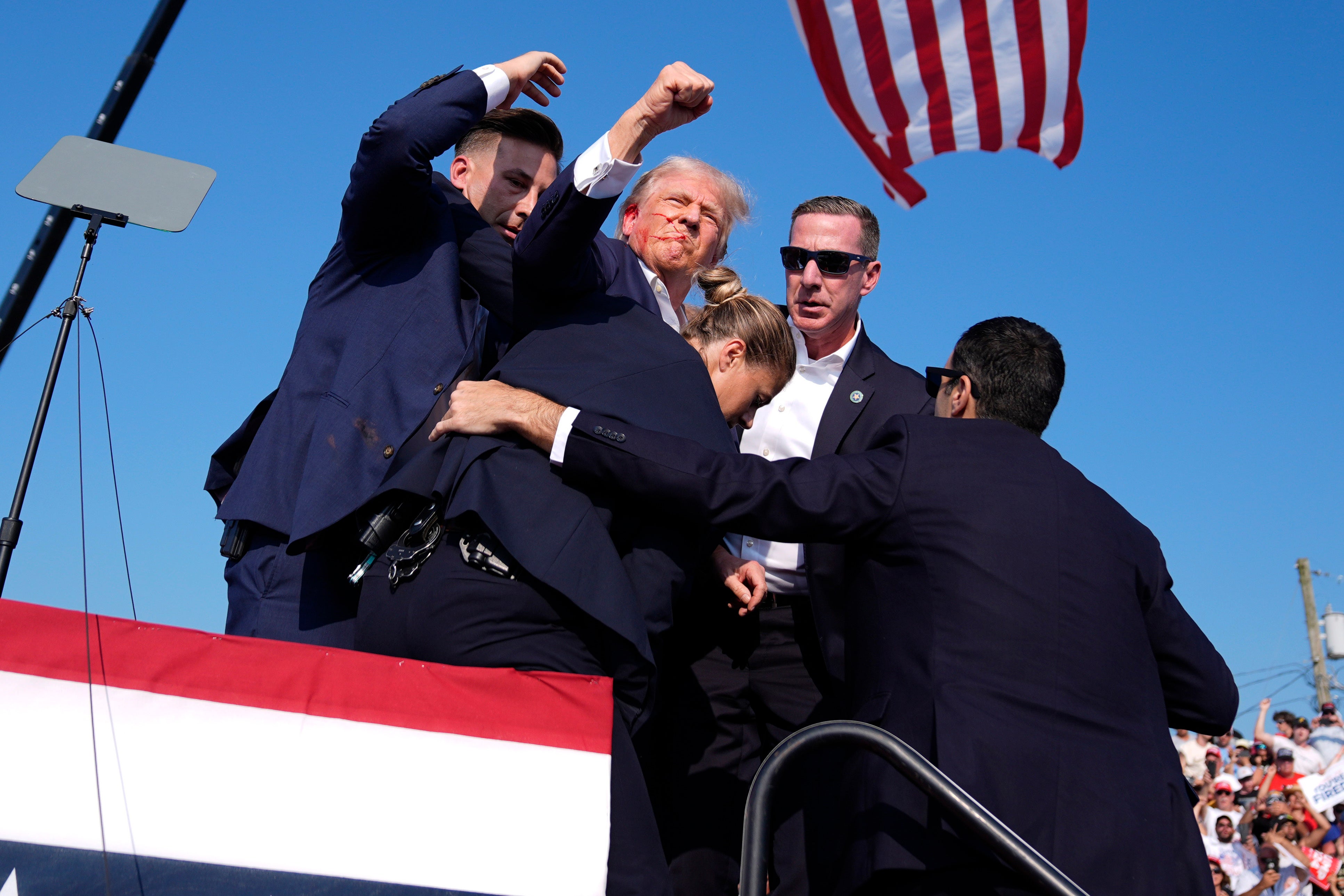 Secret Service agents surround Donald Trump at a campaign rally on Saturday, July 13, 2024, shortly after gunshots