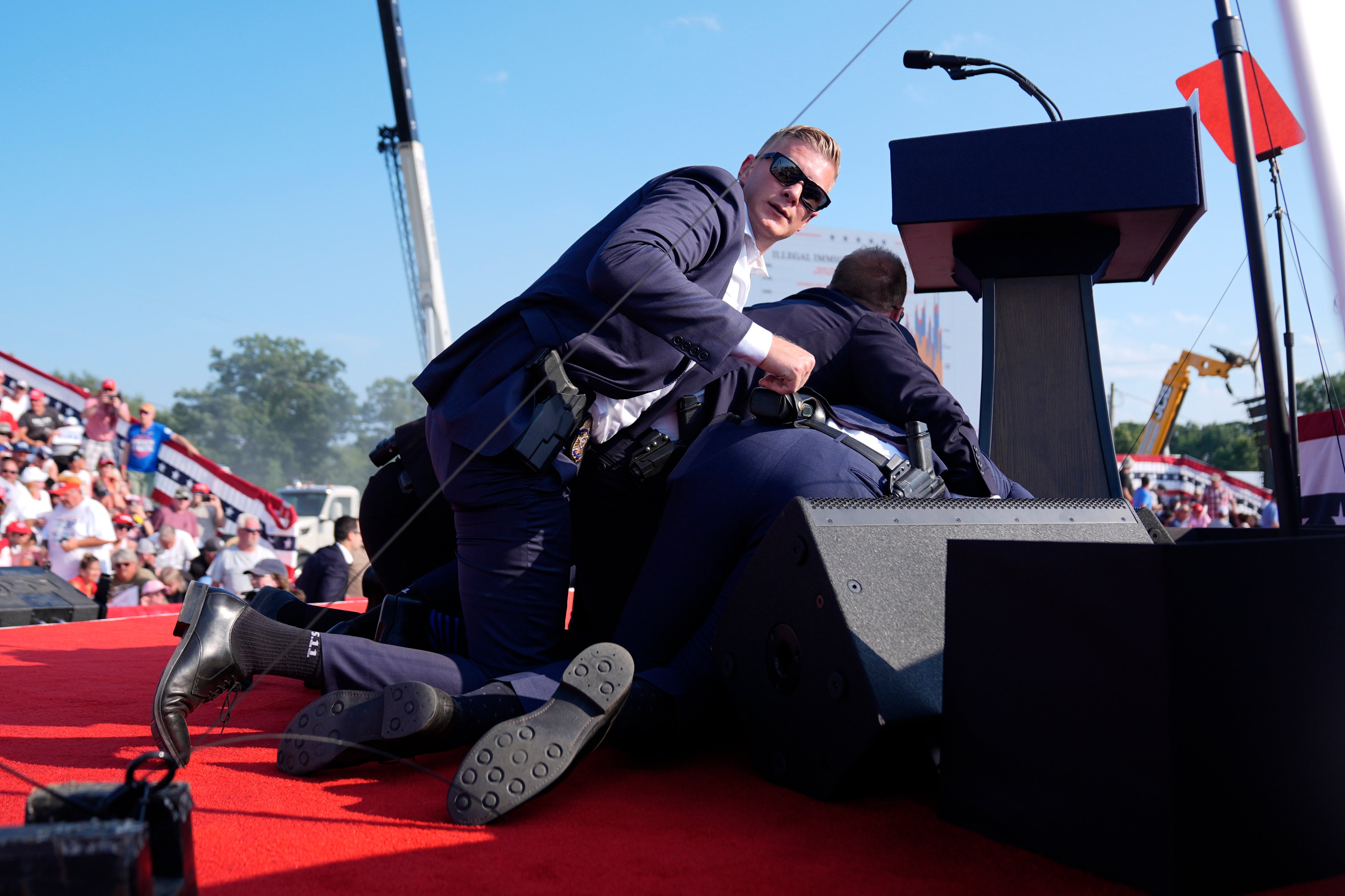 Secret Service agents rushed the stage and formed a barrier around Trump as they moved him to a waiting motorcade