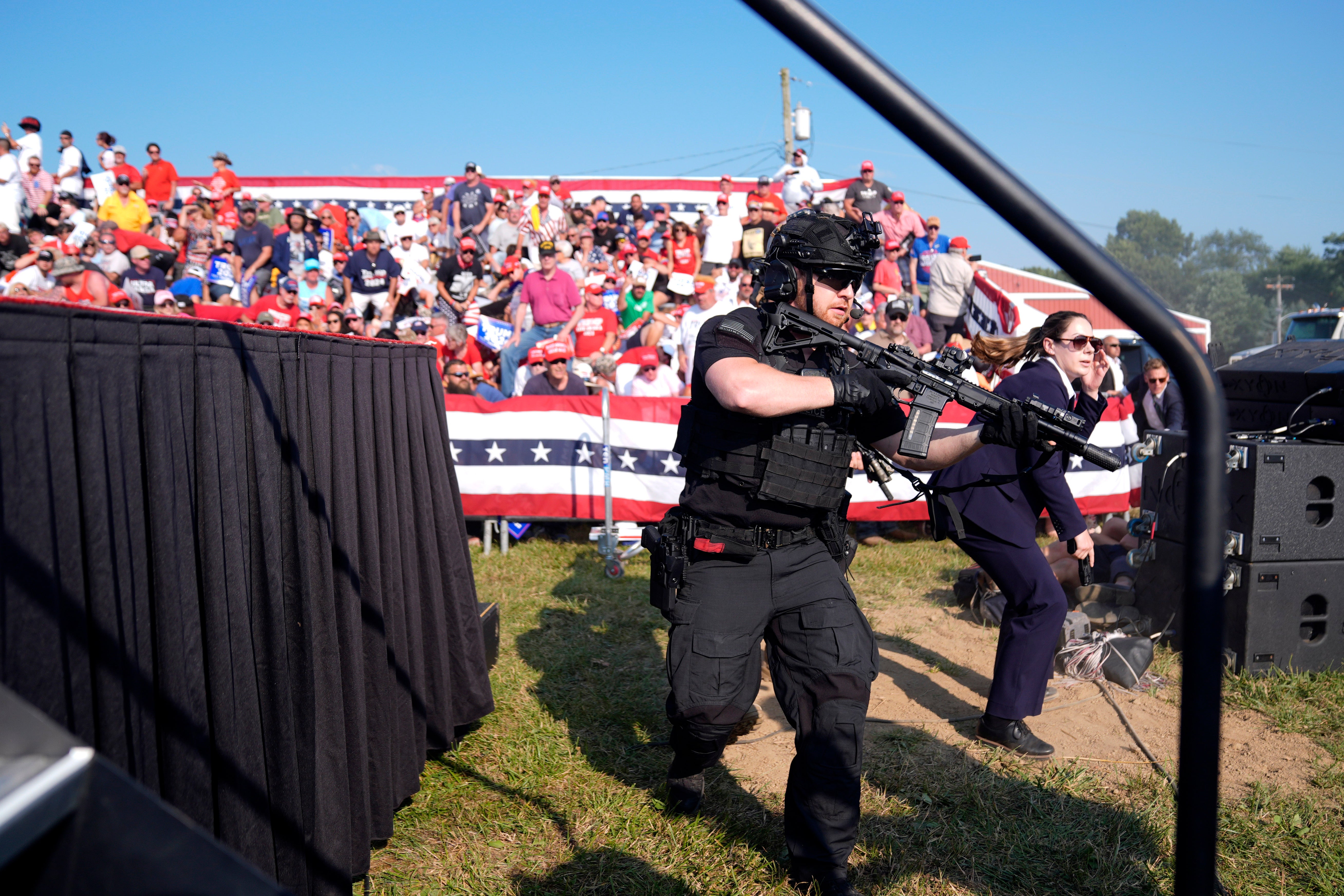 Secret Service agents rush the stage during a campaign rally with former President Donald Trump