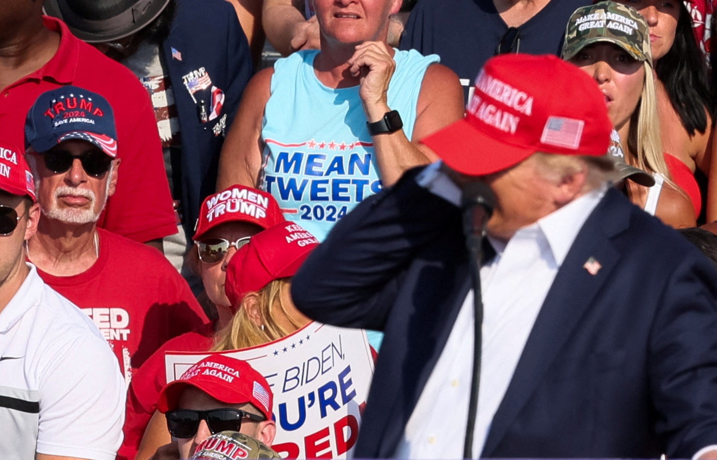 Donald Trump holds his ear after a gunman fires several shots