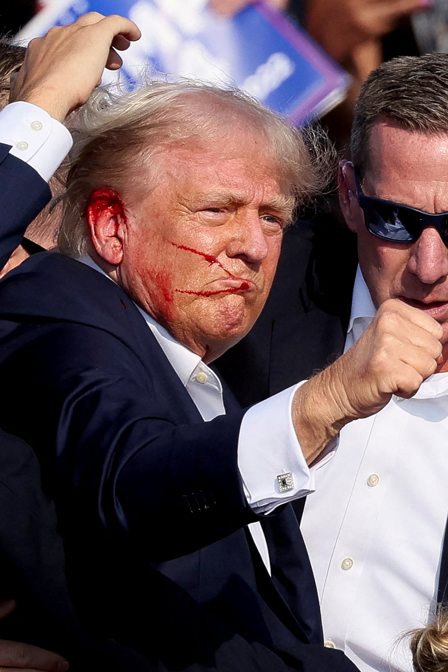 Donald Trump raises his fist to a campaign rally crowd after he appeared to be struck by gunfire on July 13.