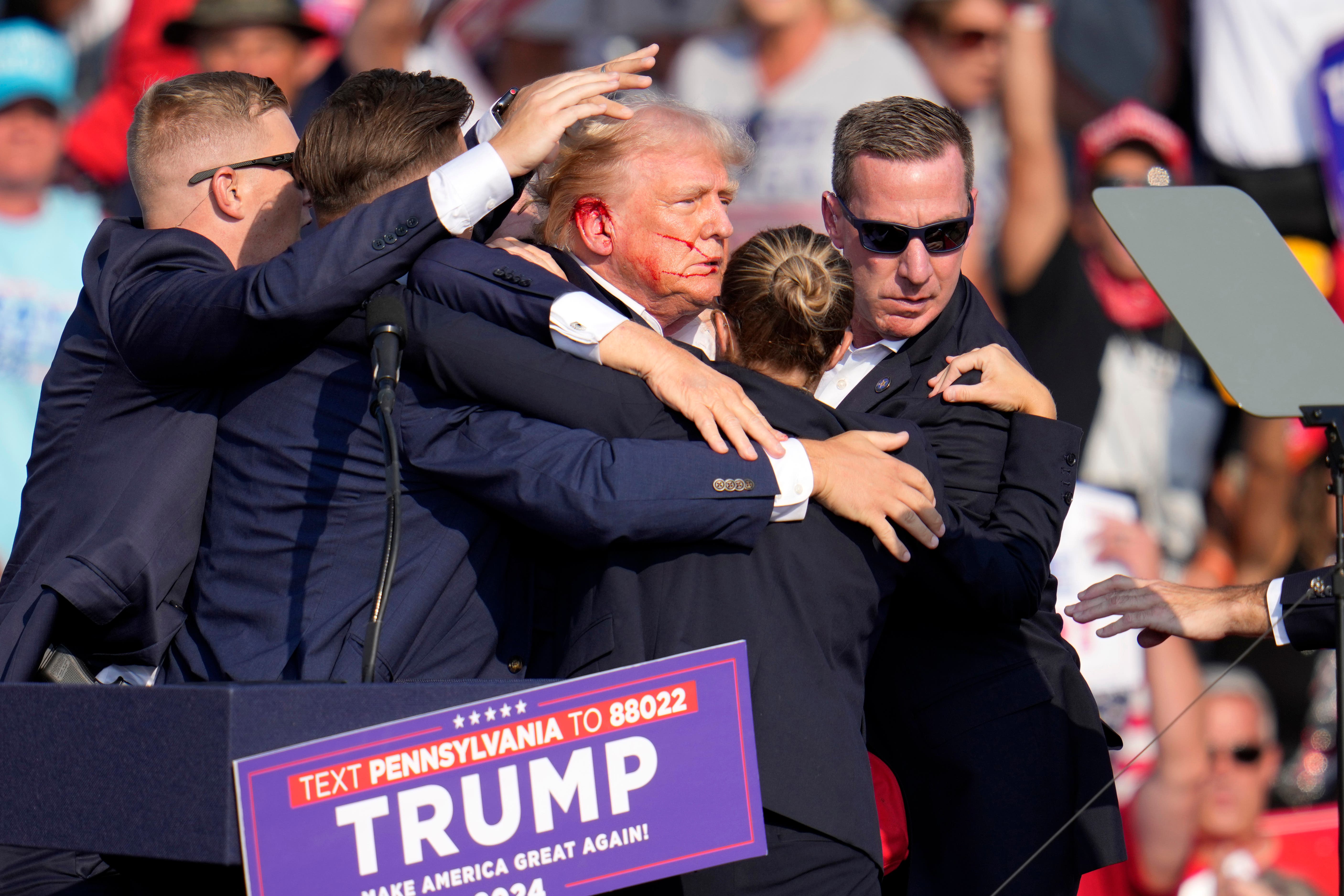 Former president Donald Trump is helped off the stage at a campaign event (Gene J Puskar/AP)