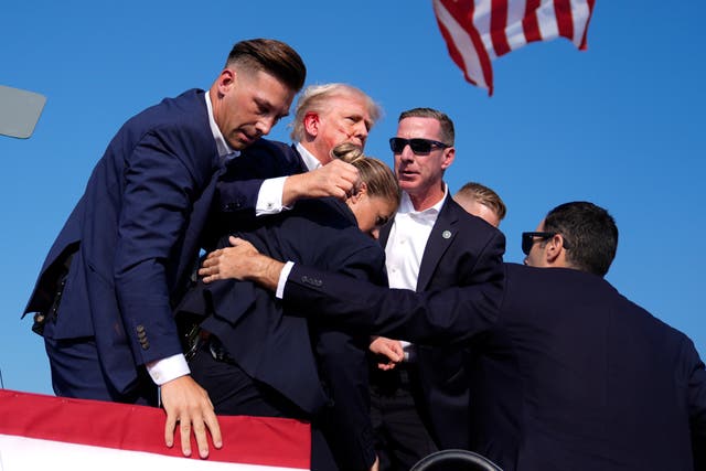 <p>Donald Trump is surrounded by Secret Service agents at a campaign rally, Saturday, July 13, 2024, in Butler, Pennsylvania after being shot </p>