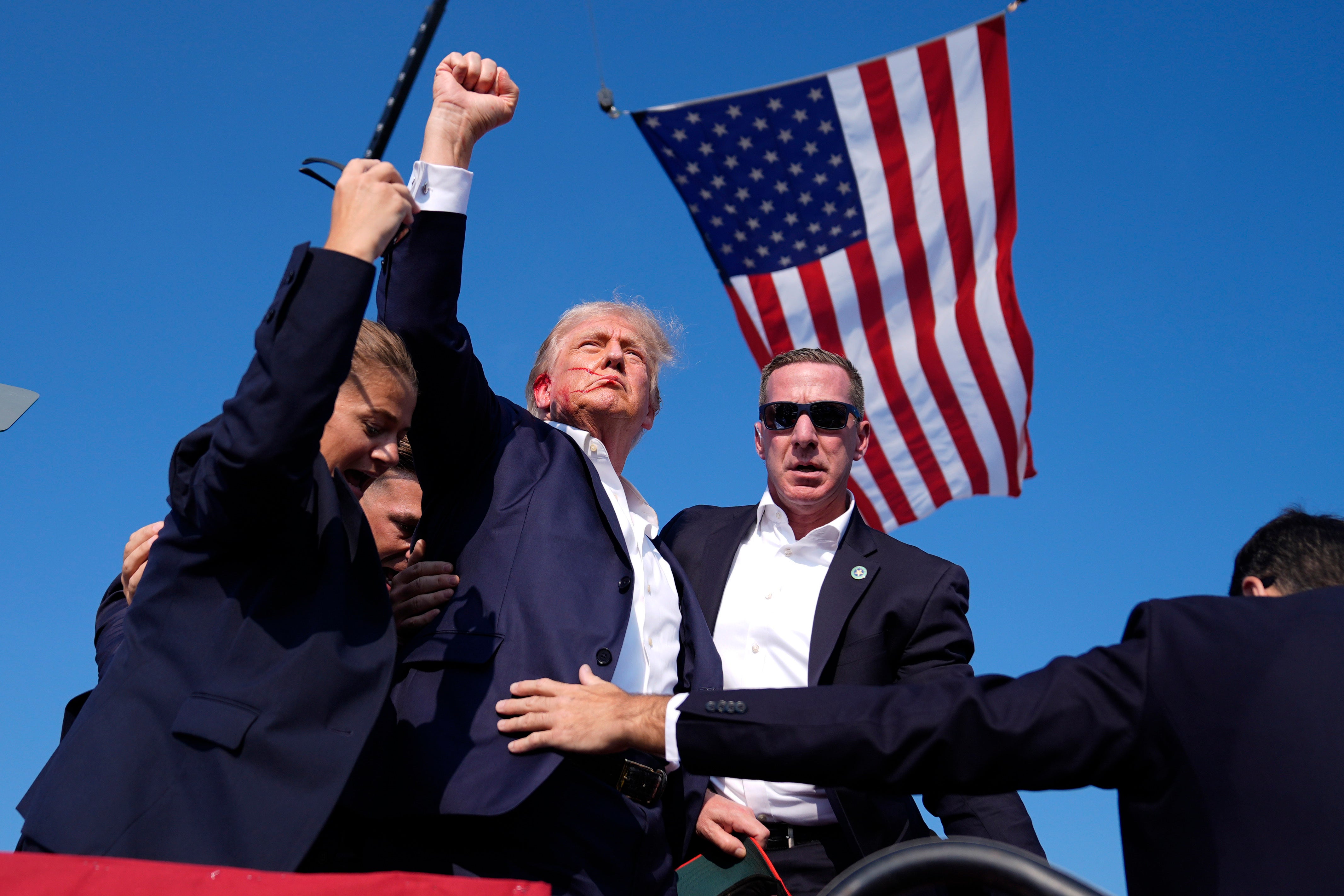 Donald Trump reacts as he is surrounded by US Secret Service agents