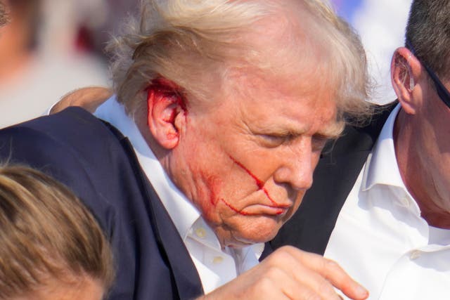 <p>A bloodied Donald Trump after shots were fired during the rally </p>