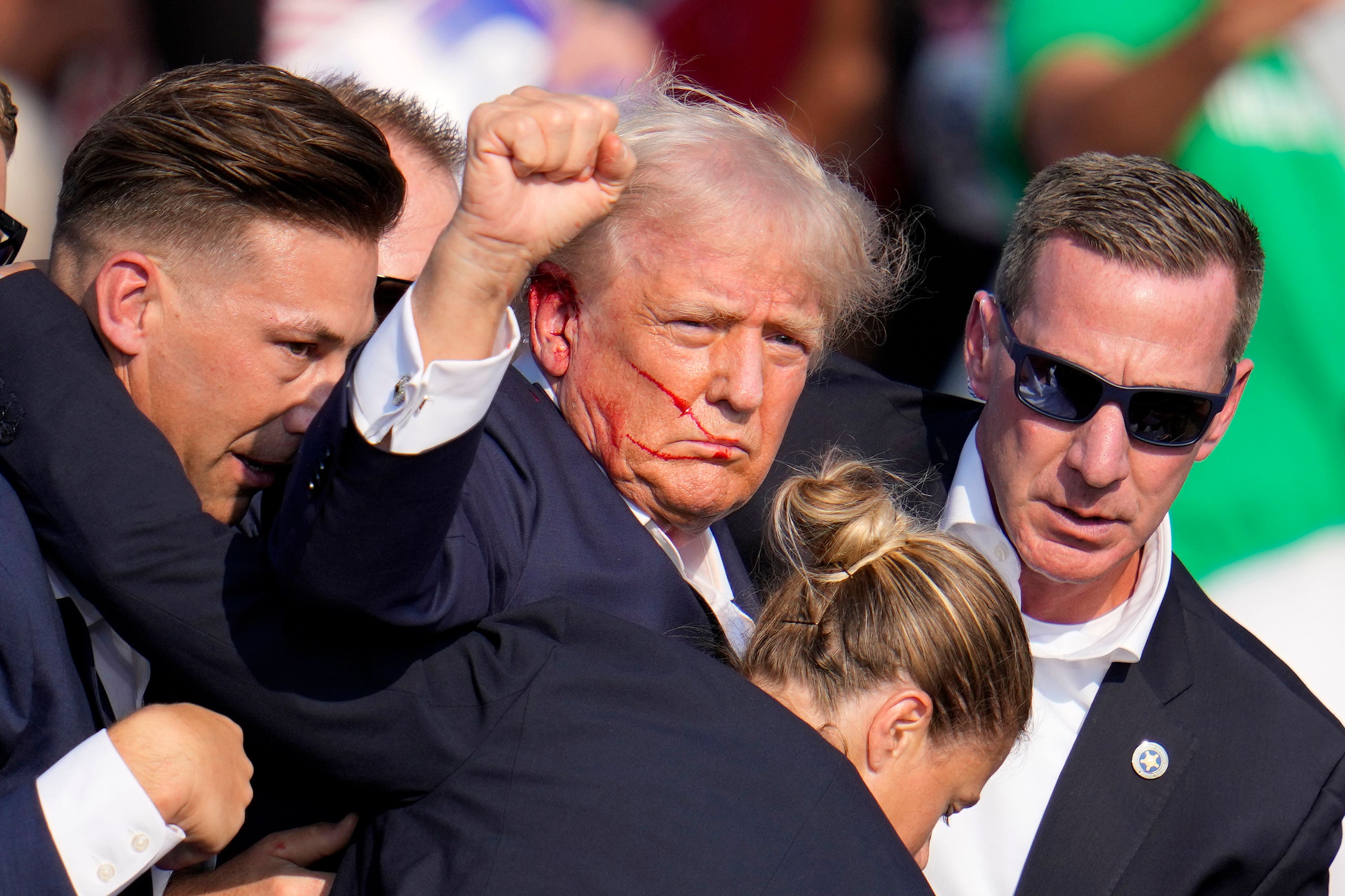 Former president Trump raises his fist to the crowd after being shot on stage at the rally