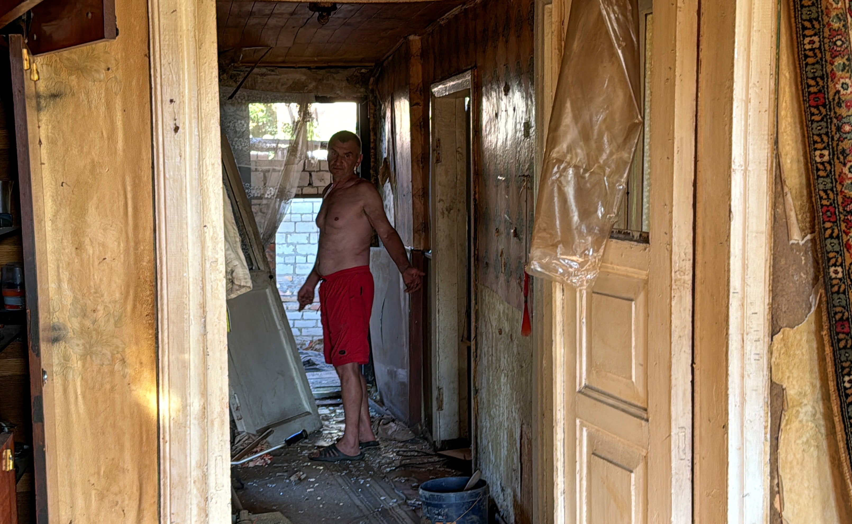 A local resident reacts as he stands at his house damaged by a Russian missile strike, amid Russia's attack on Ukraine, in the village of Budy, Kharkiv region