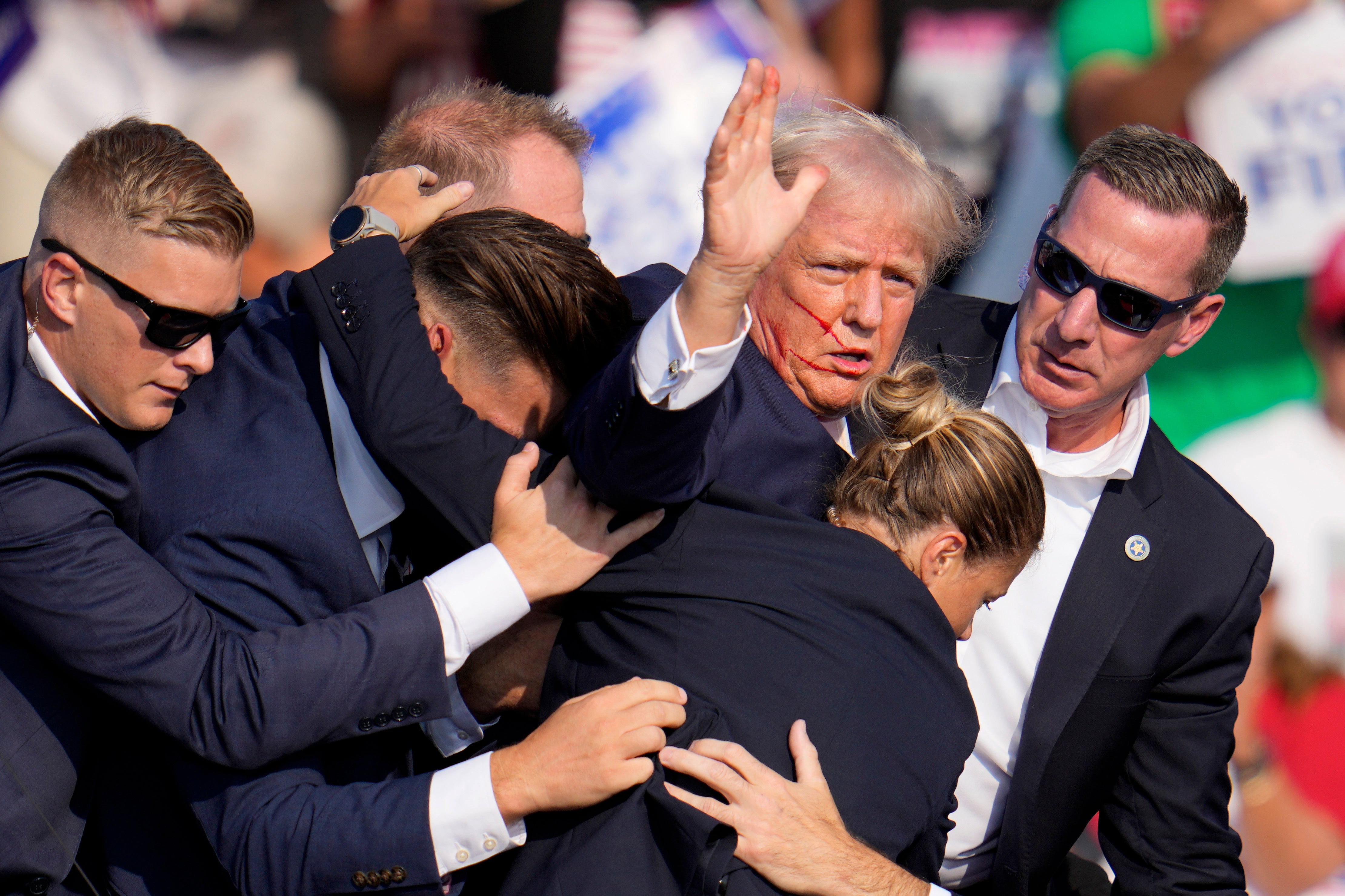 Mr Trump was helped off stage by US Secret Service agents (Gene J Puskar/AP)