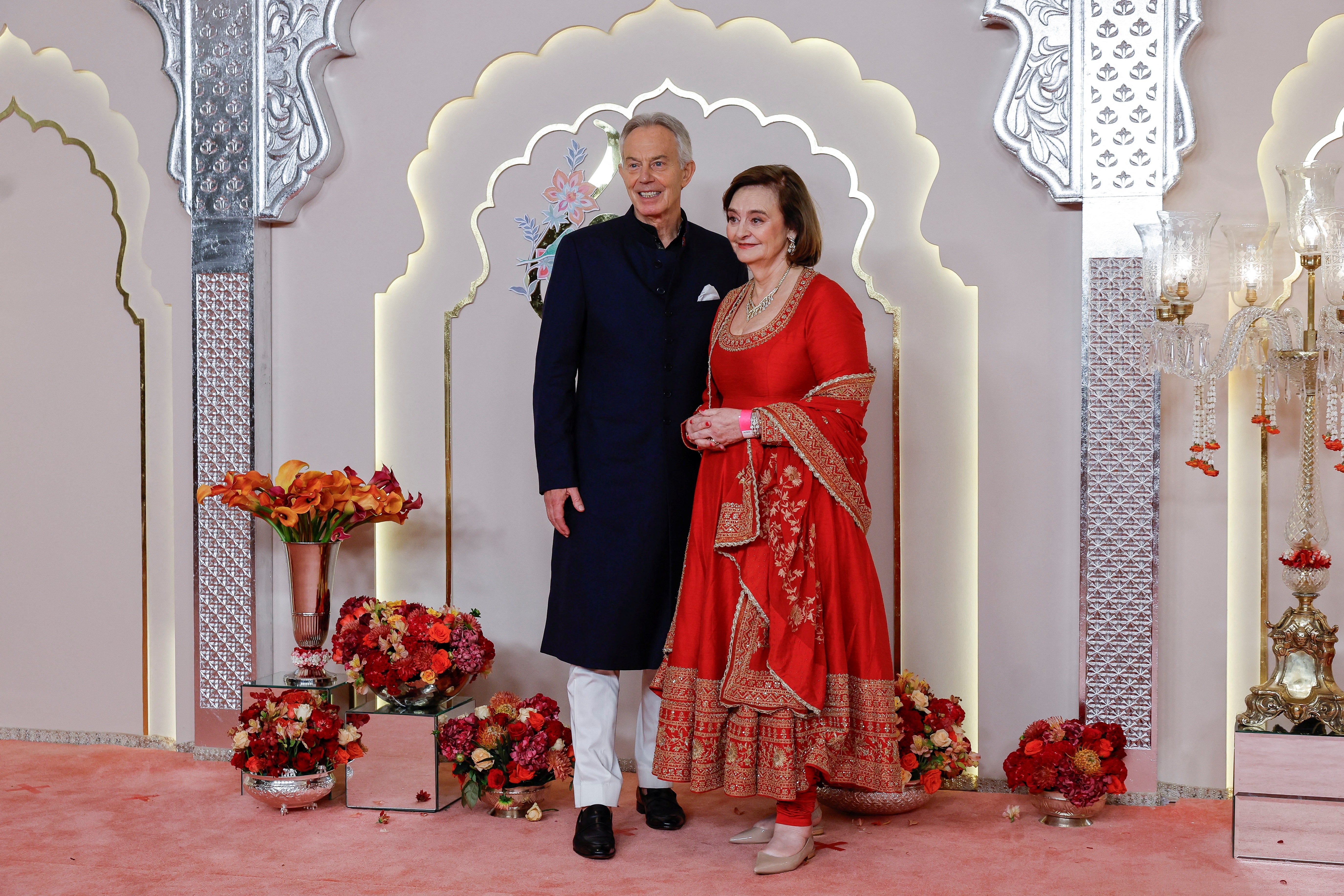 Former British Prime Minister Tony Blair and his wife Cherie Blair pose for pictures on the red carpet on the day of the wedding of Anant Ambani and Radhika Merchant in Mumbai