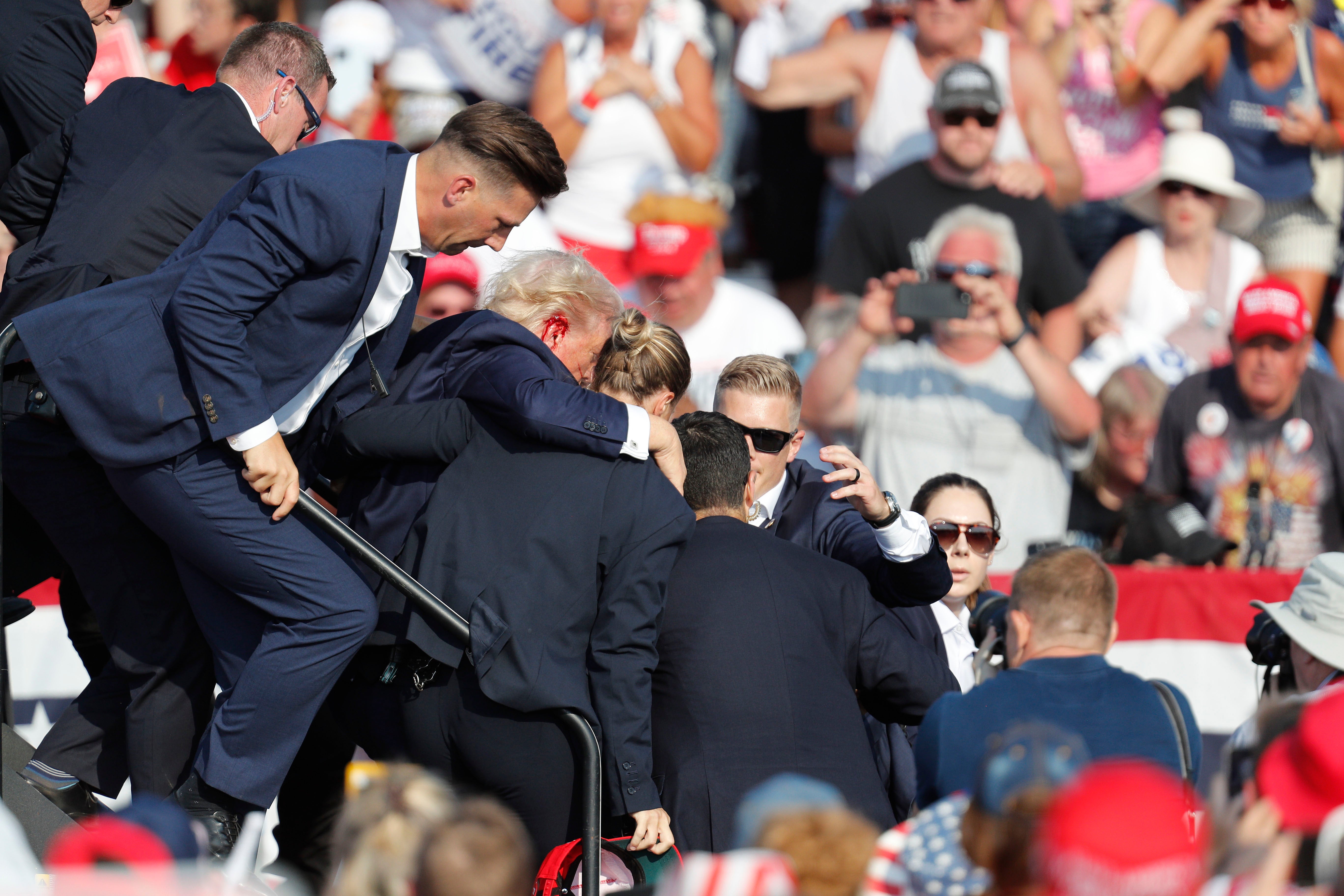 Donald Trump is rushed from stage by Secret Service after being shot at during a campaign rally in Butler, Pennsylvania