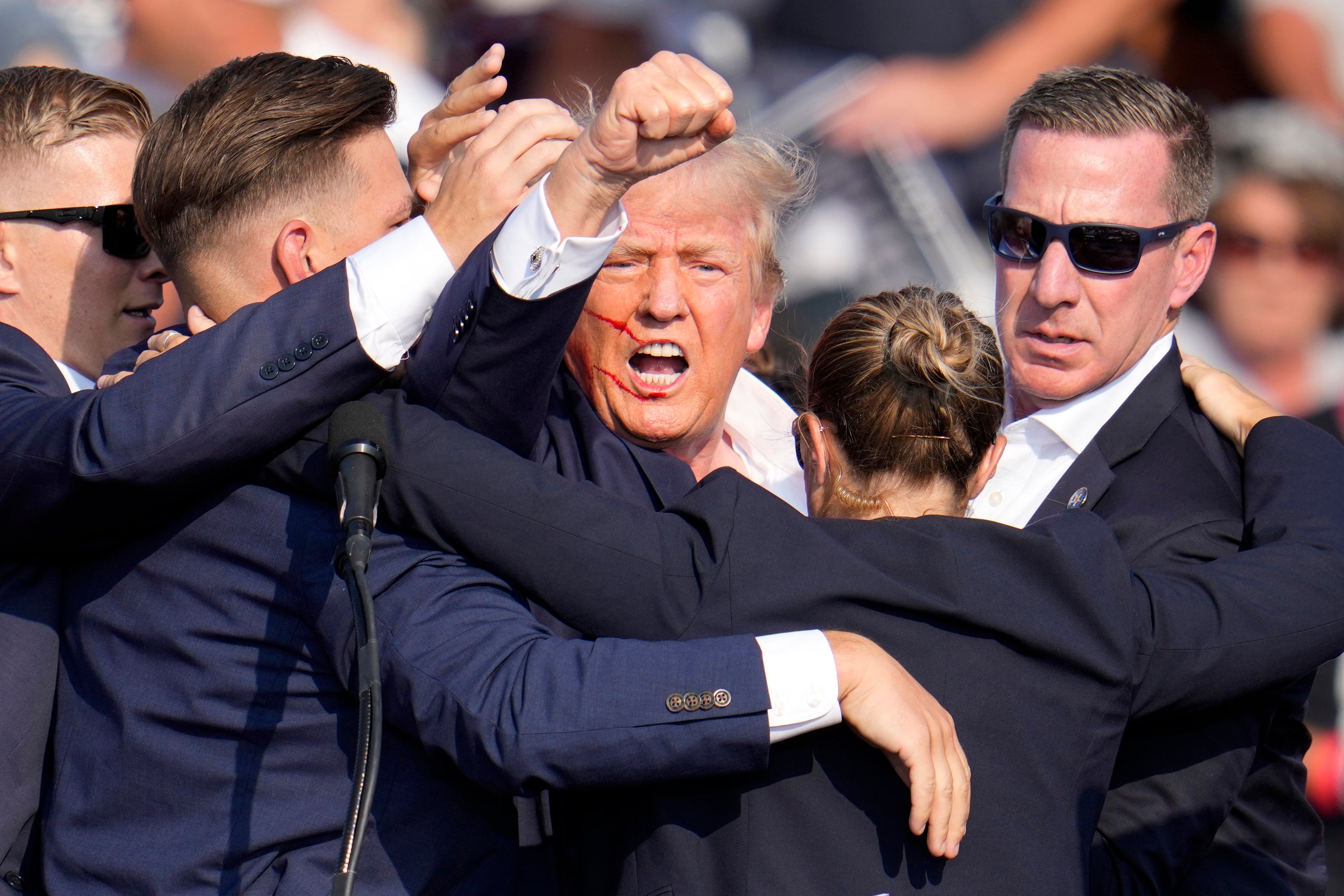 Republican presidential candidate former President Donald Trump is helped off the stage by U.S. Secret Service agents at a campaign event in Butler, Pa., on Saturday, July 13, 2024. (AP Photo/Gene J. Puskar)