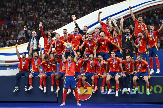 <p>Alvaro Morata hoists the European Championship trophy aloft</p>
