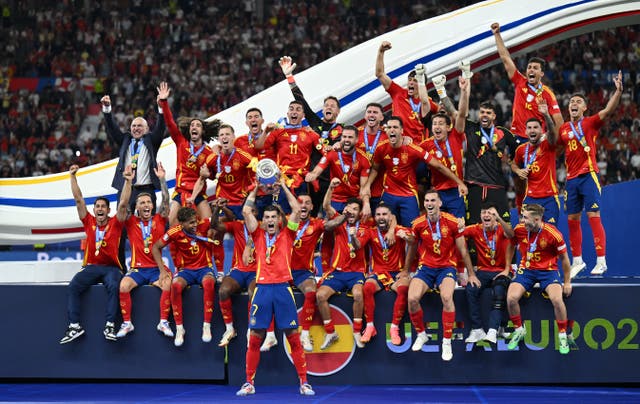 <p>Alvaro Morata hoists the European Championship trophy aloft</p>