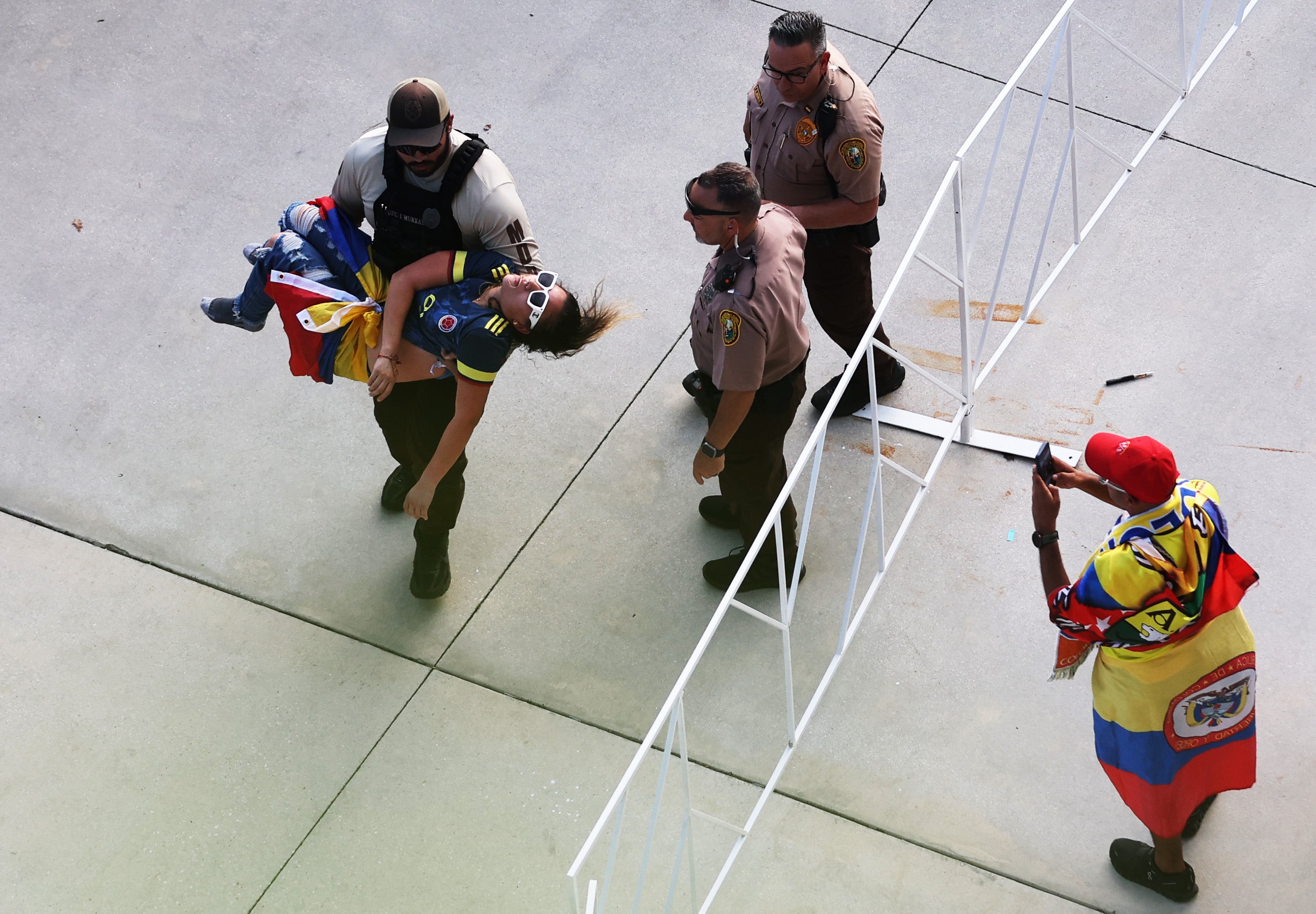 A police officer carries an unconscious fan