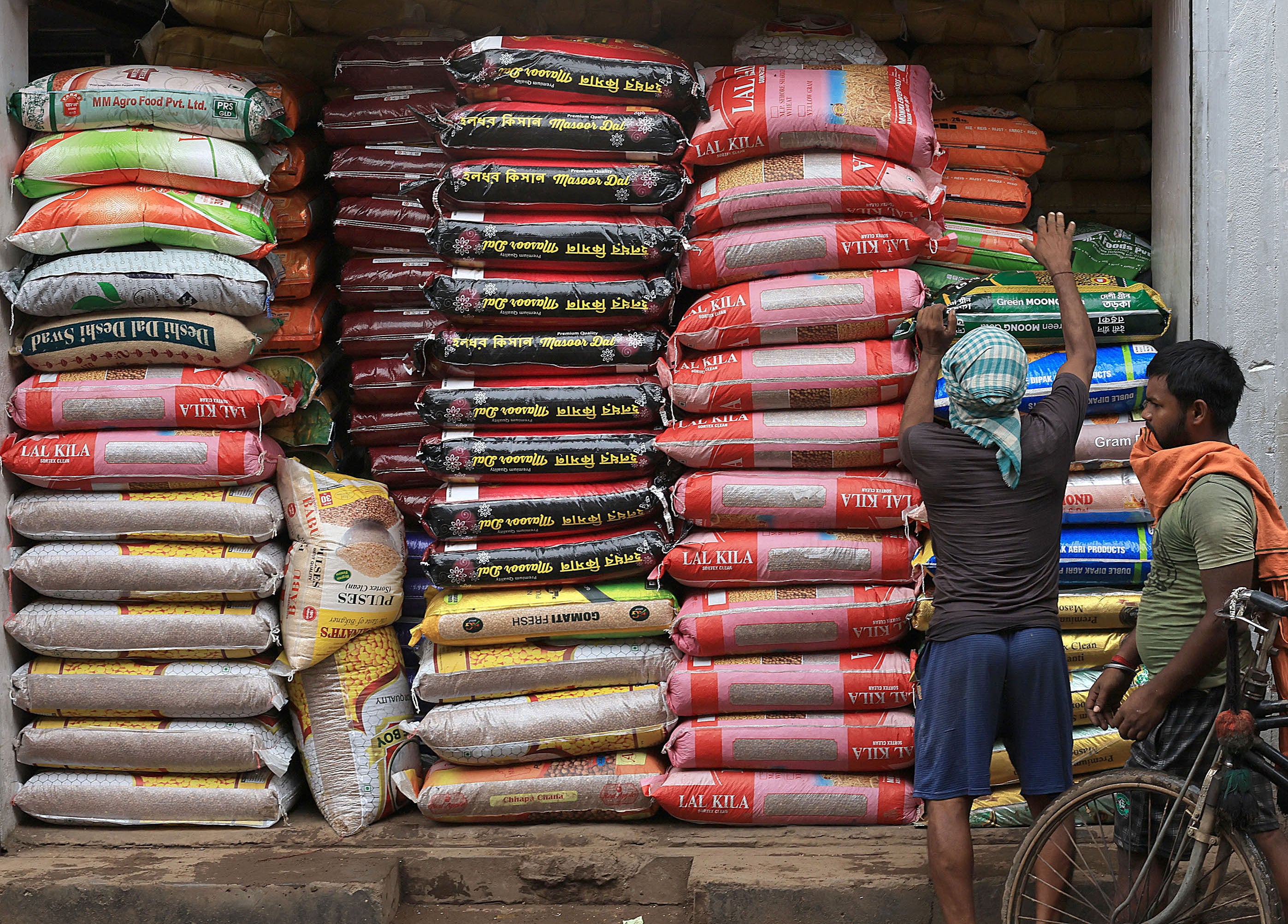 Indian workers pile lentil bags in Kolkata on 12 July 2024