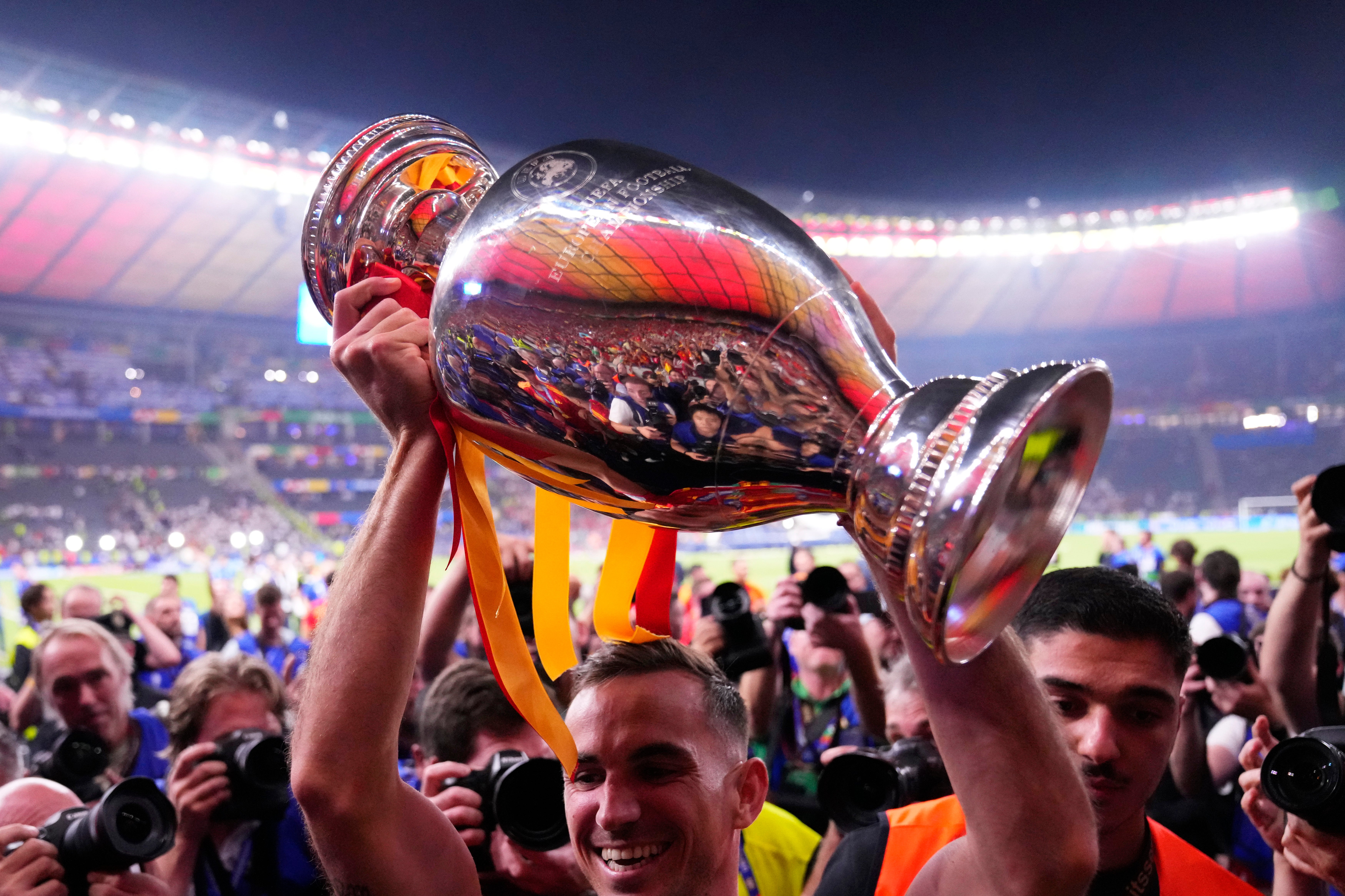Spain's Dani Olmo holds up the trophy to the fans after winning the final match between Spain and England