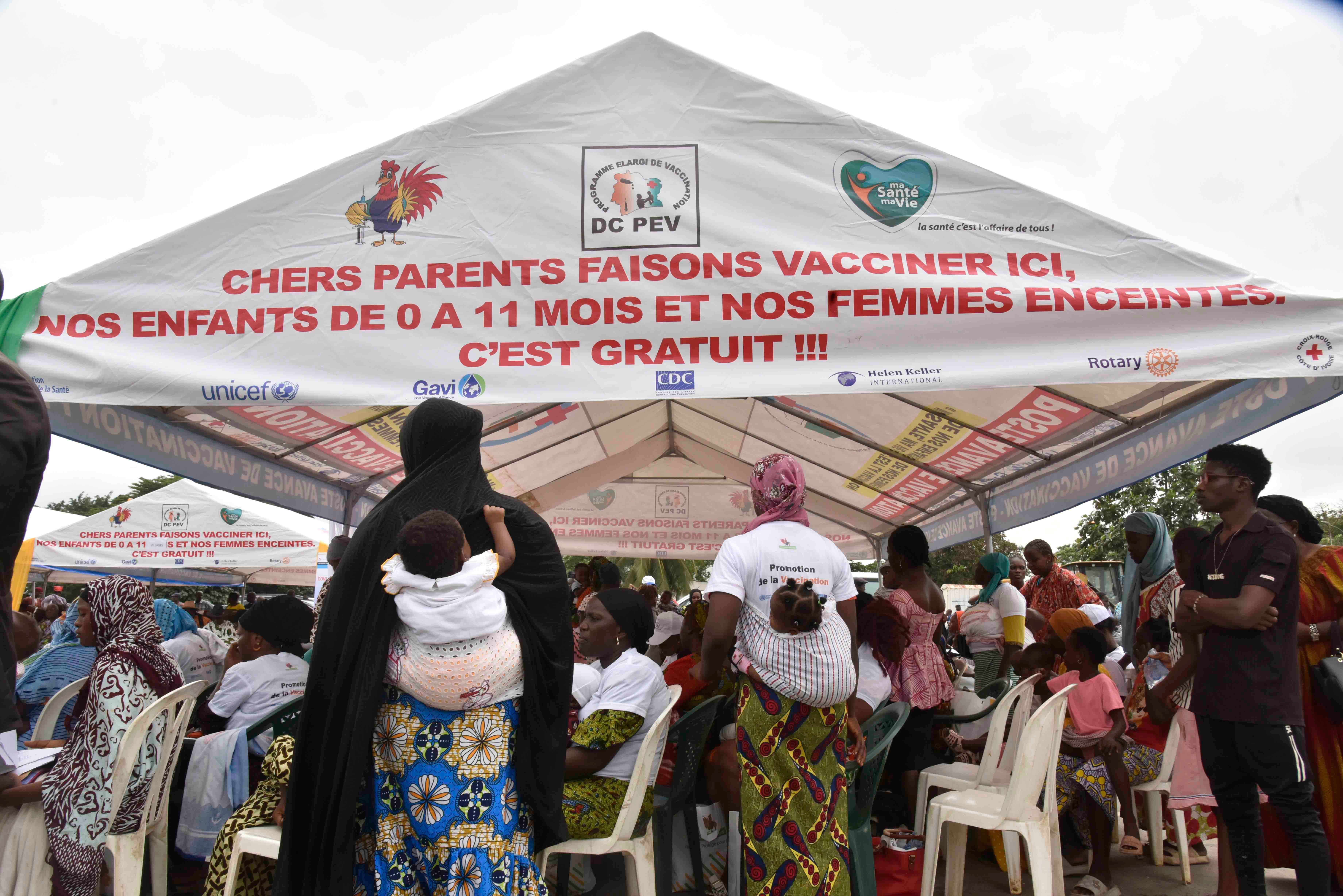 Women wait to administer the malaria vaccine Oxford-Serum R21 to their children