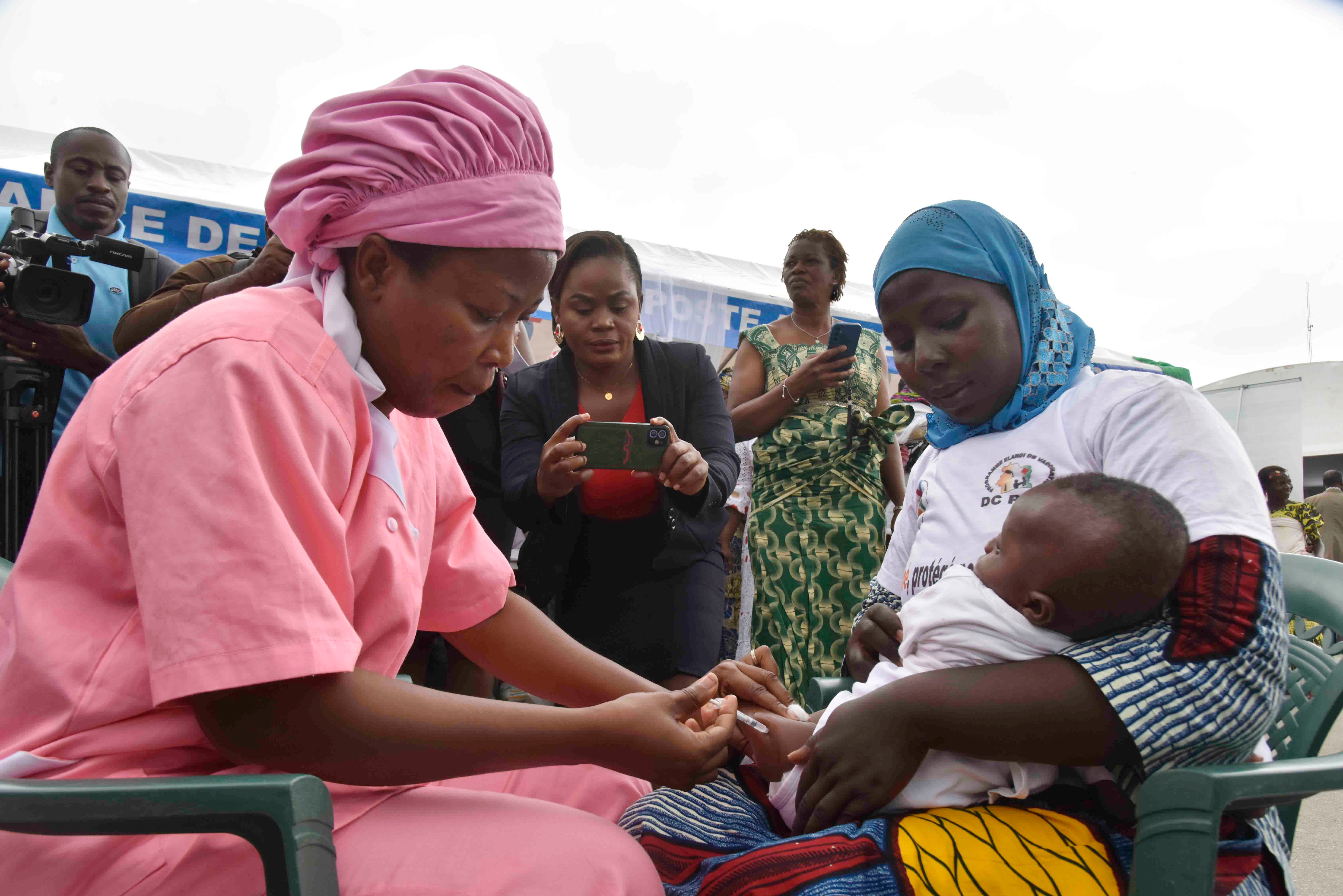 A health worker administers the malaria vaccine Oxford-Serum R21 to a child in Abidjan