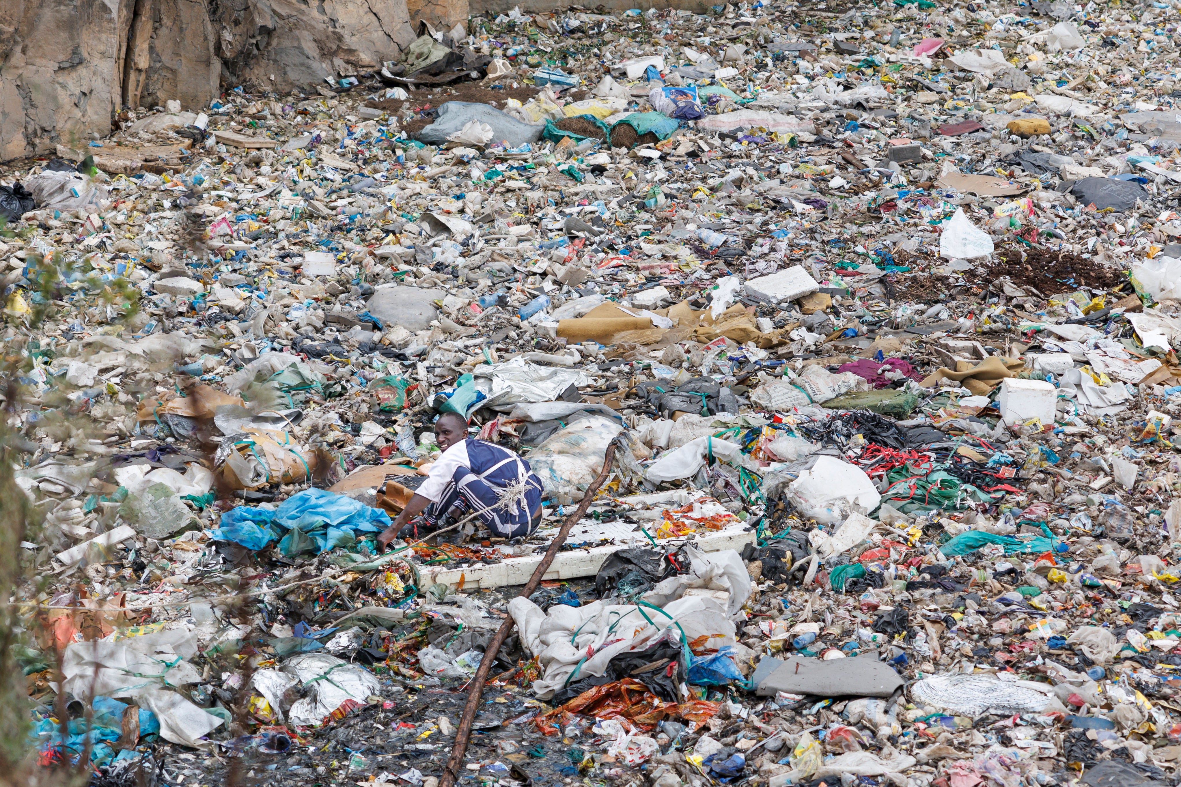 A volunteer searches through a dumpsite for human remains in the Mukuru slum on 14 July 2024