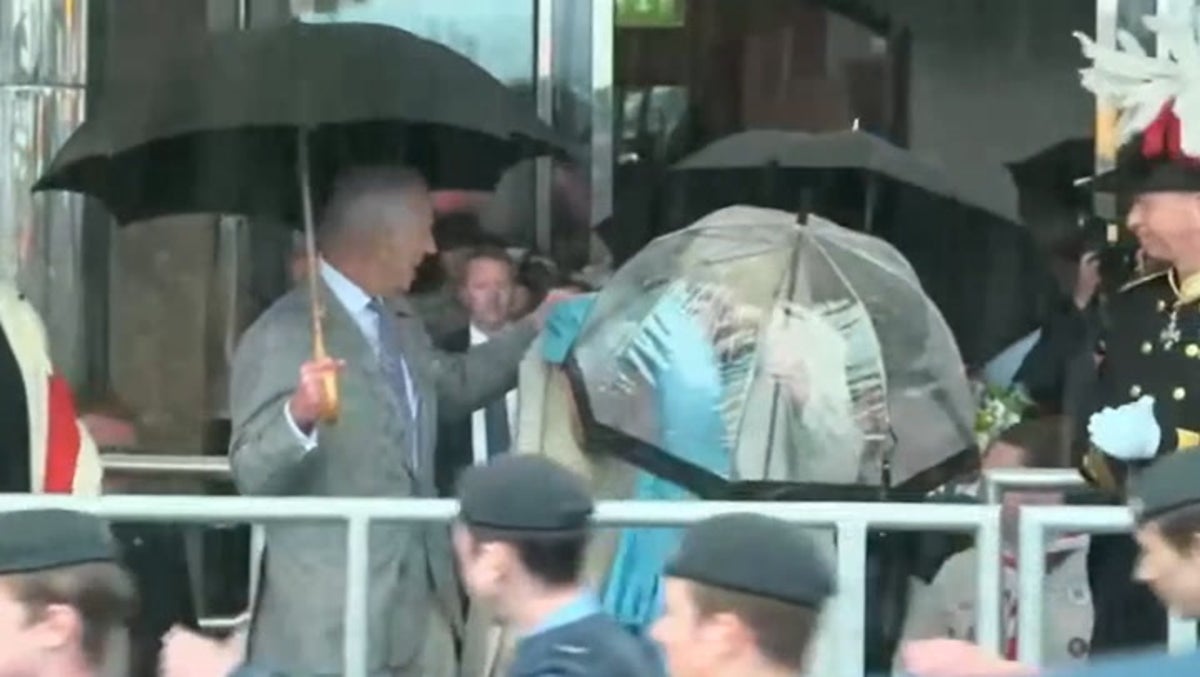 King appears to snap at aide to help Queen struggling in heavy rain