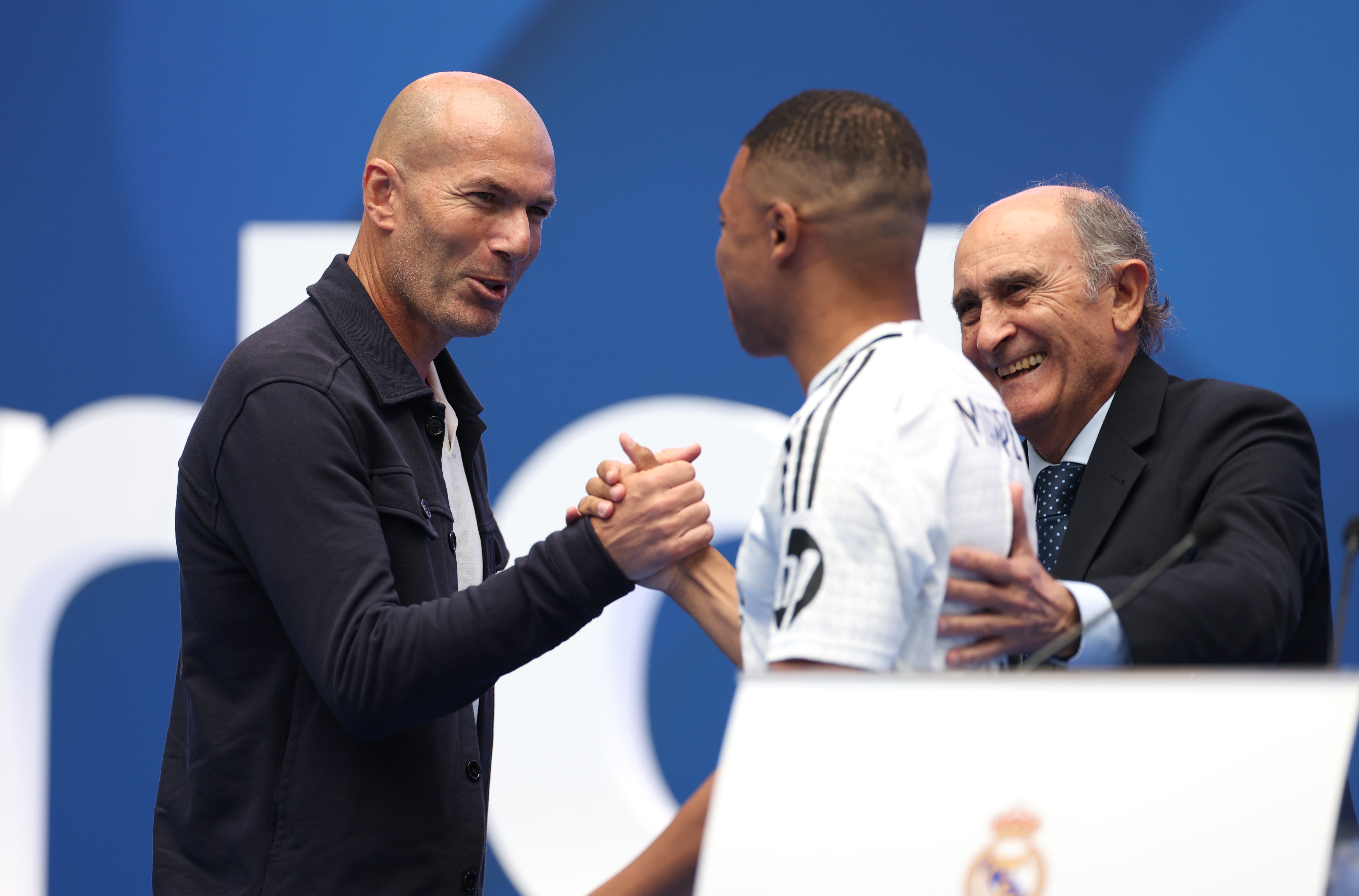 Kylian Mbappe, centre, clasps hands with Zinedine Zidane (Isabel Infantes/PA)