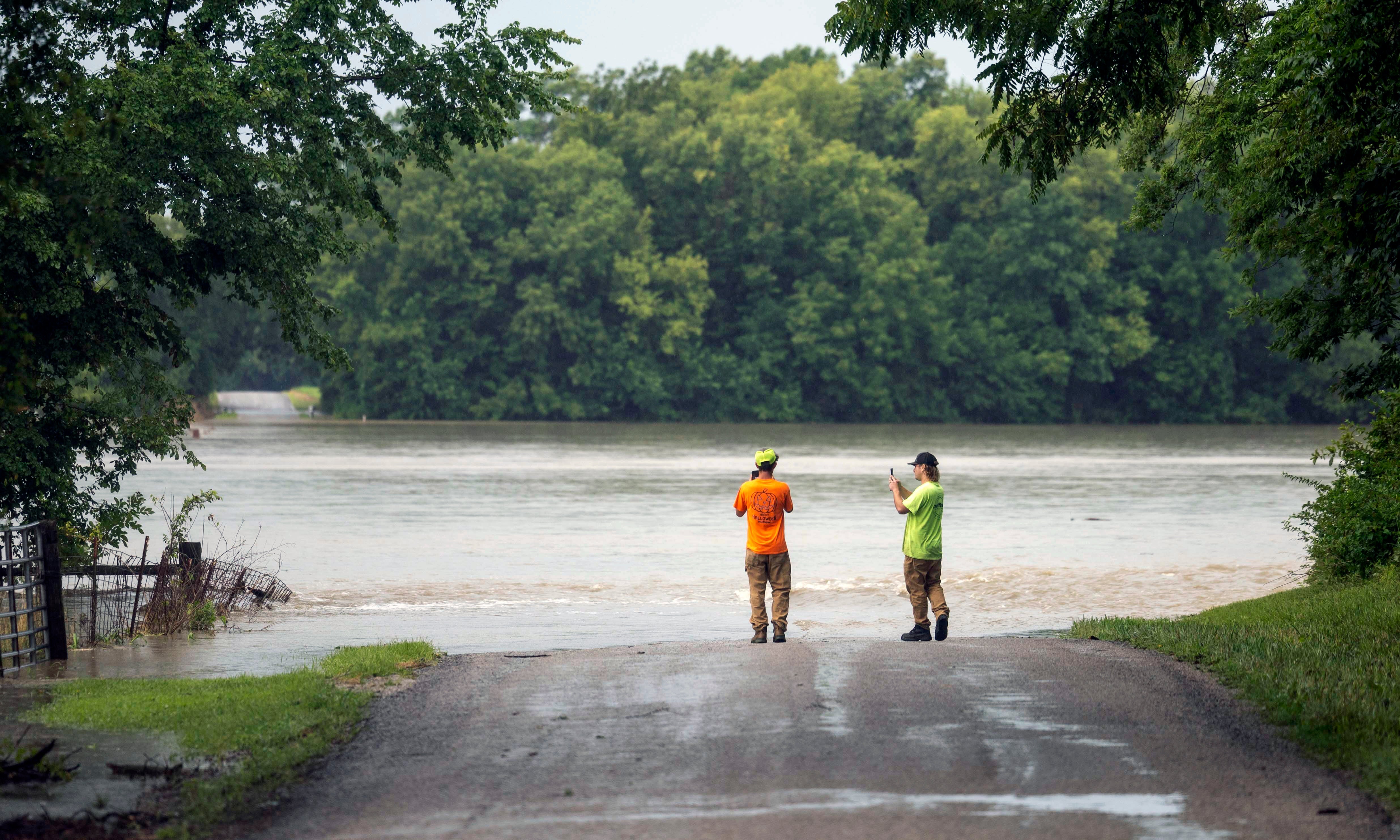 Landon Mikel, left, and John Farel, both of St. Louis, Missouri, check out the flooding on Mockingbird Road in Nashville, Ill., on Tuesday, July 16, 2024. The flooding is from a creek that rose after heavy rainfall