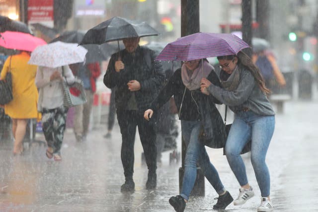 People caught in the rain on Oxford Street, central London. File photo. (Yui Mok/PA)