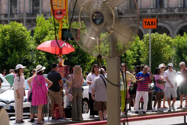 <p>Tourists wait for a bus under the sun in Milan, Italy</p>