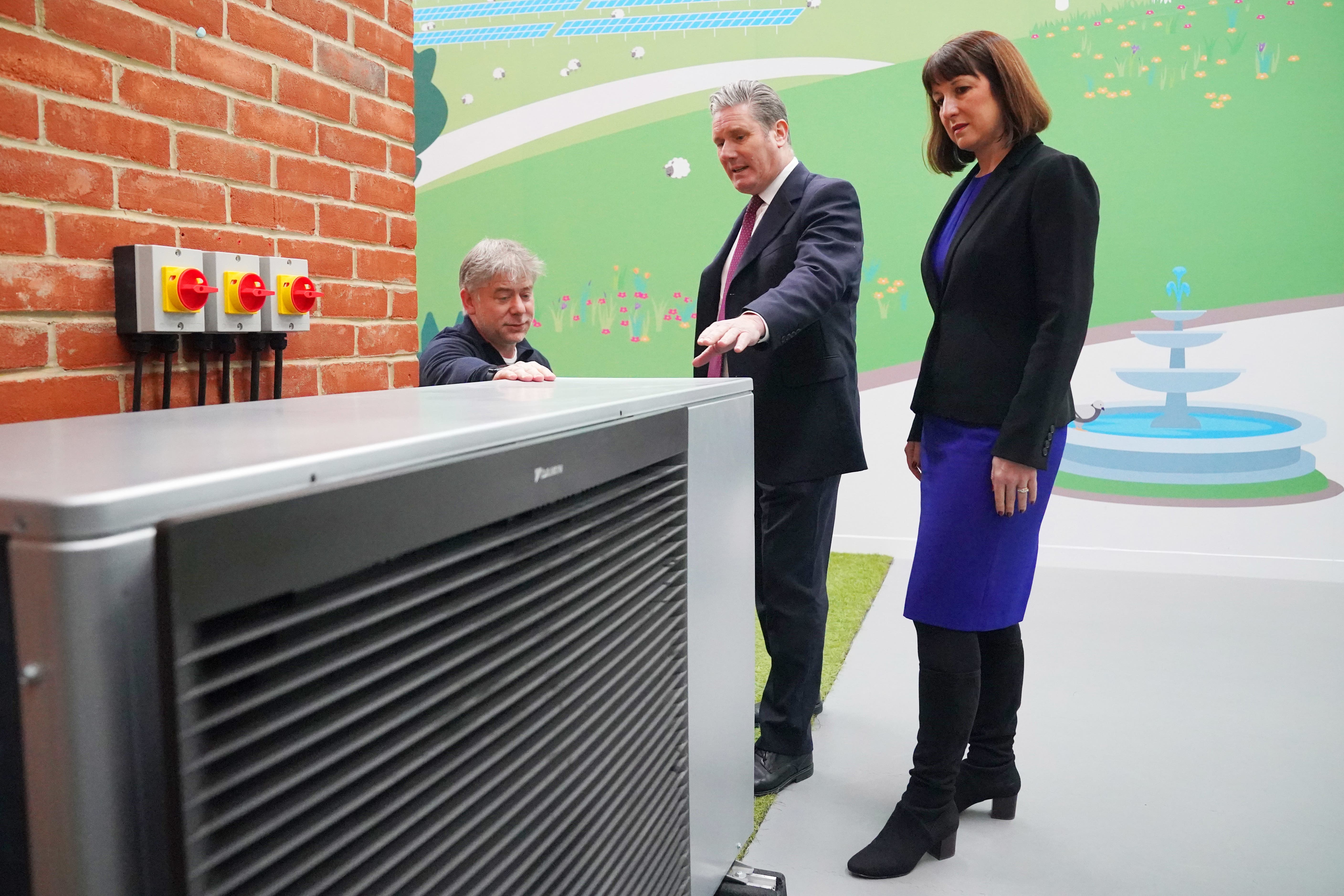 Sir Keir Starmer and Rachel Reeves are shown a heat pump demonstrator by Octopus Energy chief executive Greg Jackson as the Government was urged to reverse green policy rollbacks (Jonathan Brady/PA)