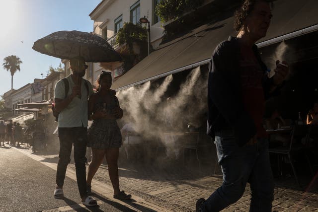 <p>Tourists walk past a terrace with a water spray device outside the Ancient Agora during a heatwave in Athens, Greece, 17 July 2024</p>